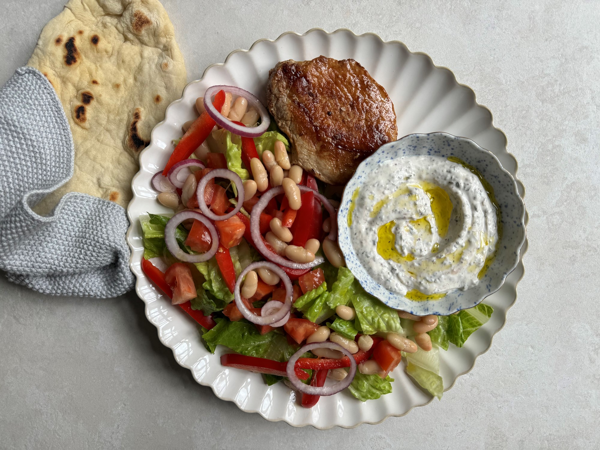 Græsk salat med lune fladbrød og koteletter