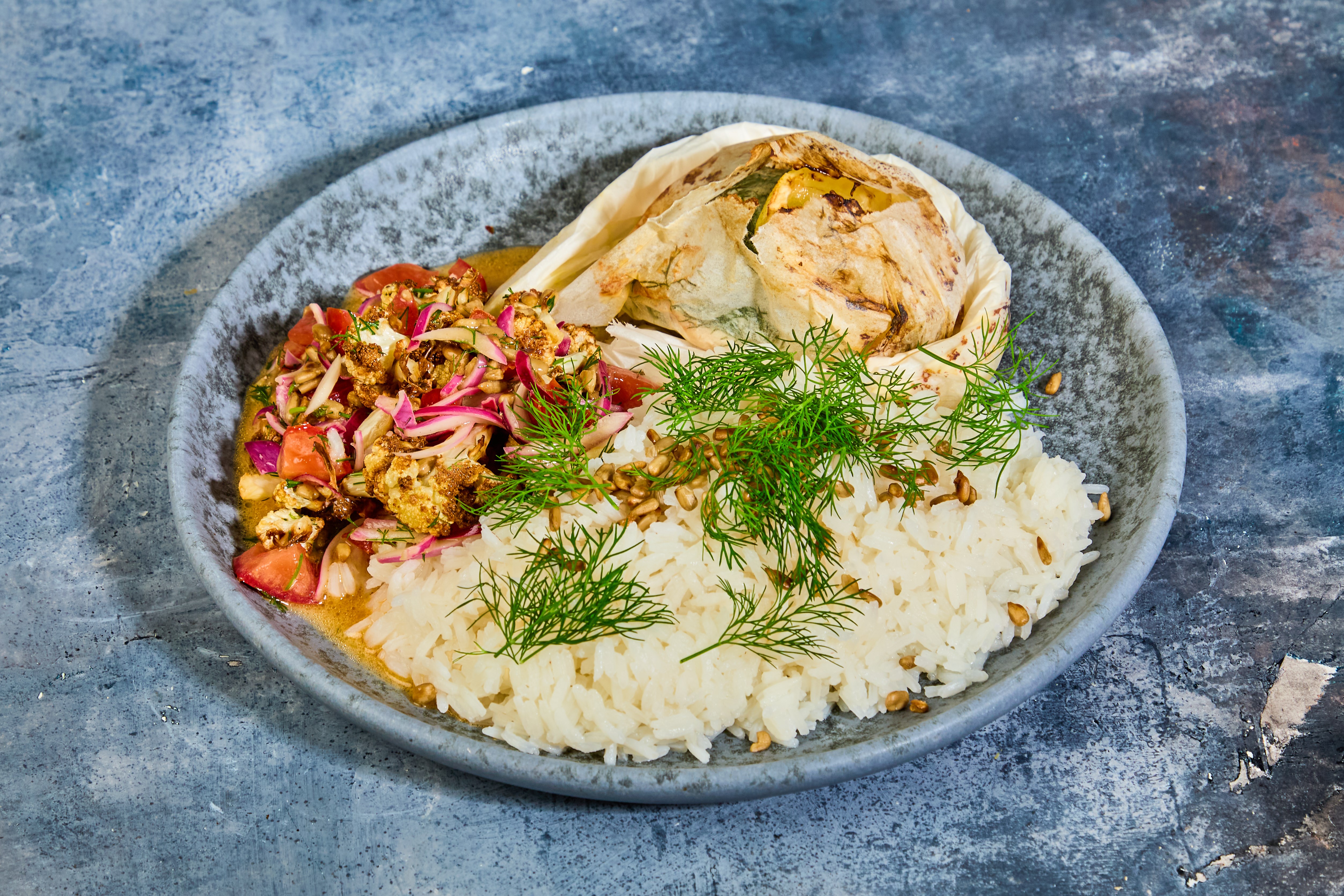 Kuller en papilotte med bagt blomkålssalat med dild og solsikkekerner i ...