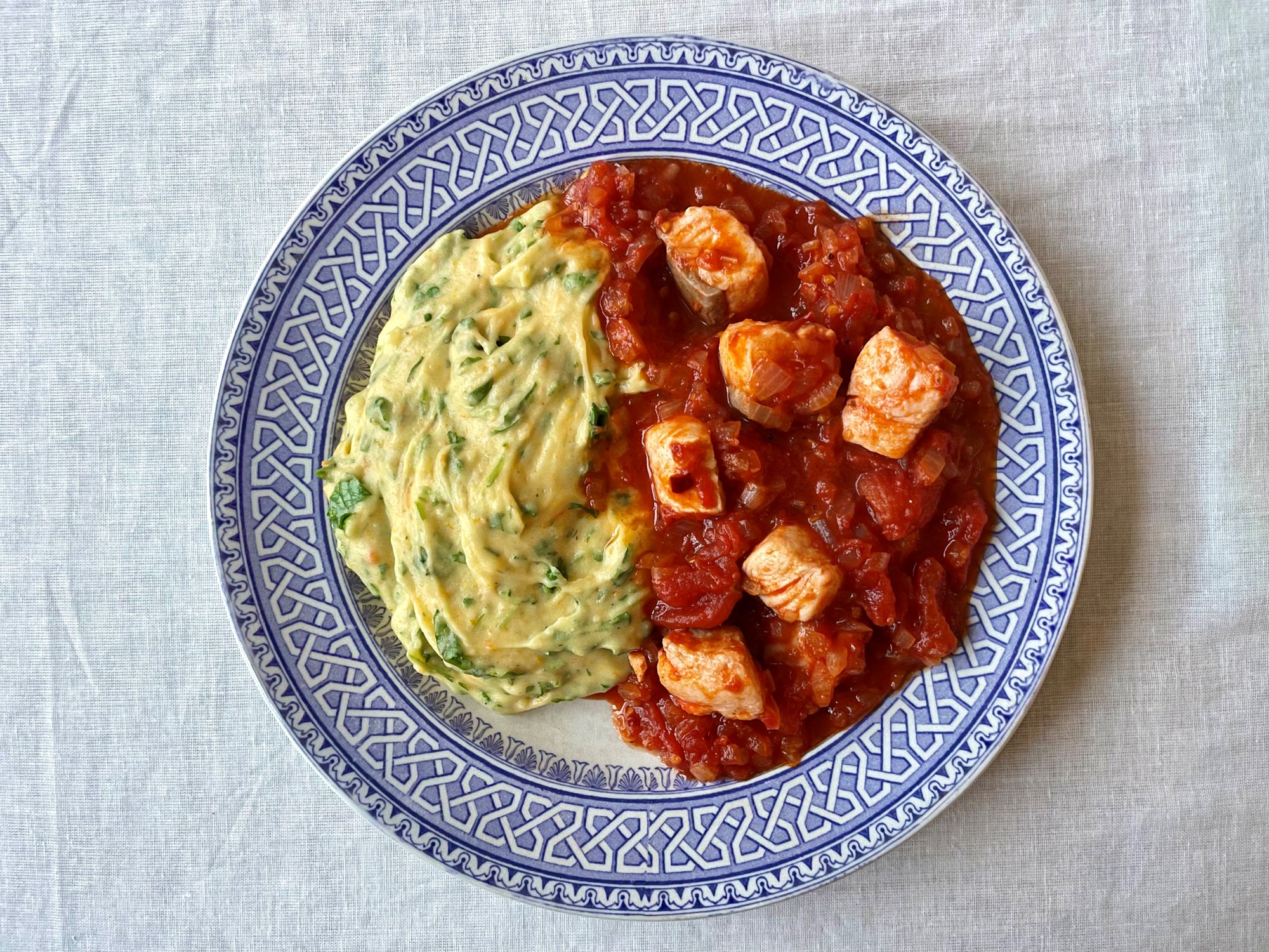 Laks i stærk tomatsovs med kartoffelmos og persille