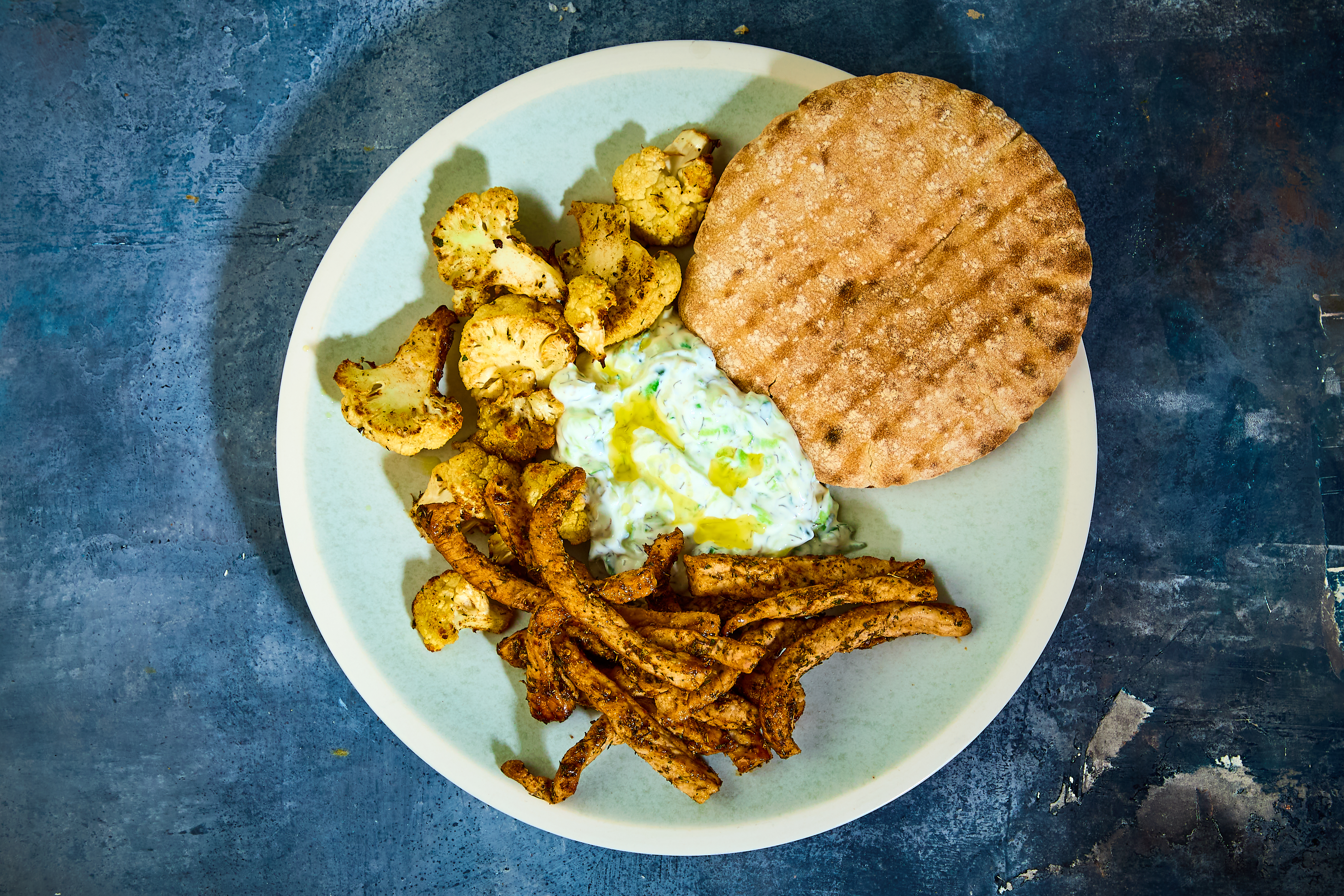 Pita med harissastegt gris, bagt blomkål og tzatziki