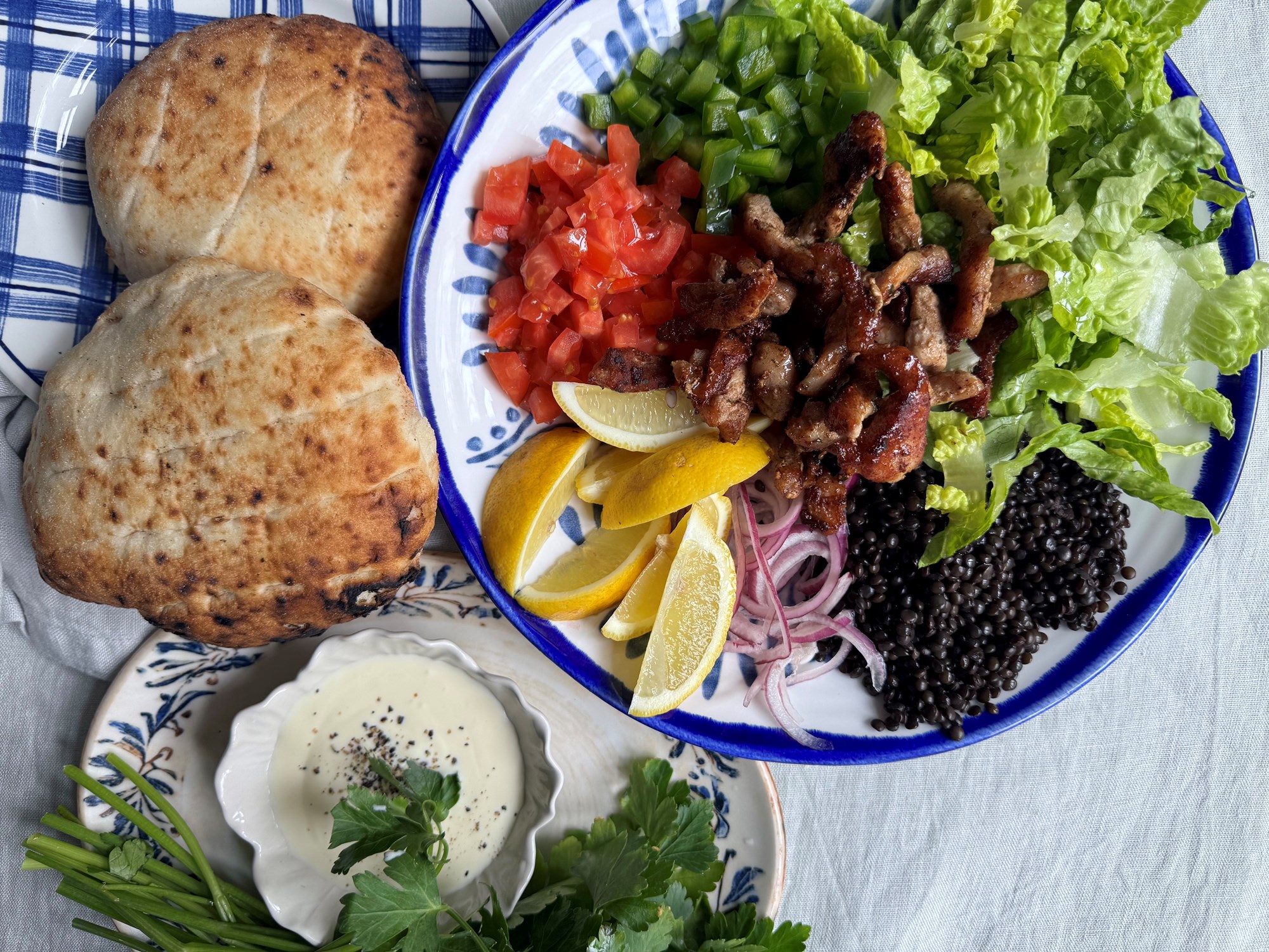 Pitabrød med krydret gris, salat og belugalinser