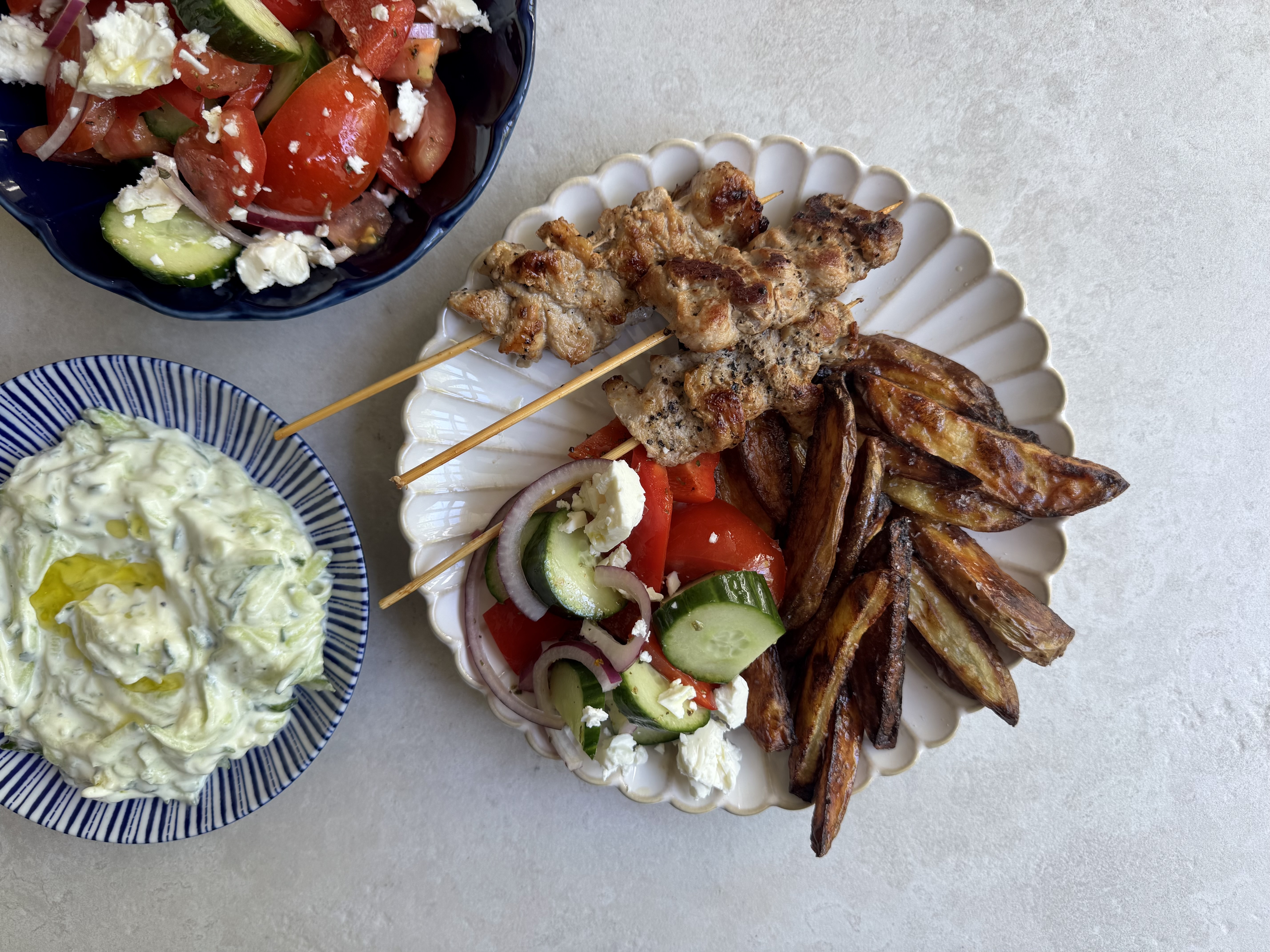Gris på spyd med ovnkartofler, tzatziki og græsk salat