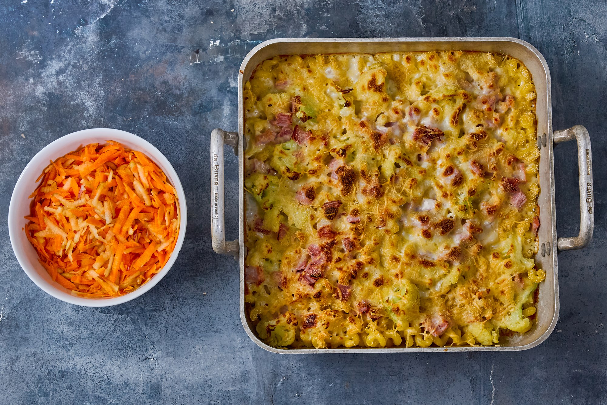 Gratin af Cavatappi-pasta med blomkål, skinke og revet ost med sprød æble-gulerodssalat