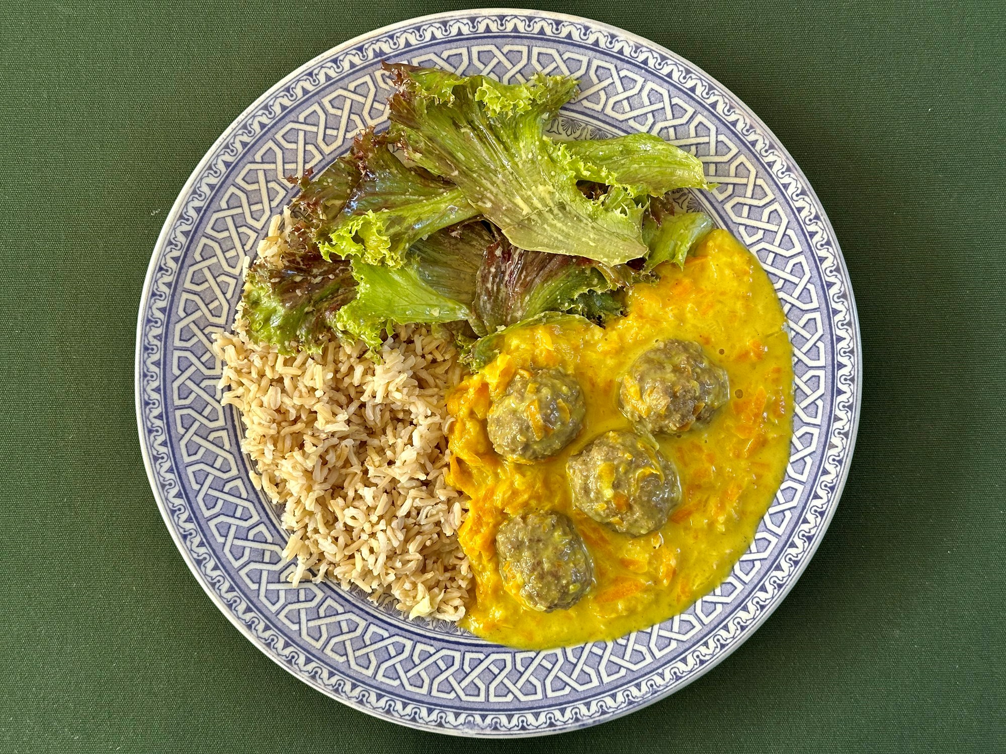 Boller i karry med brune ris og egebladssalat