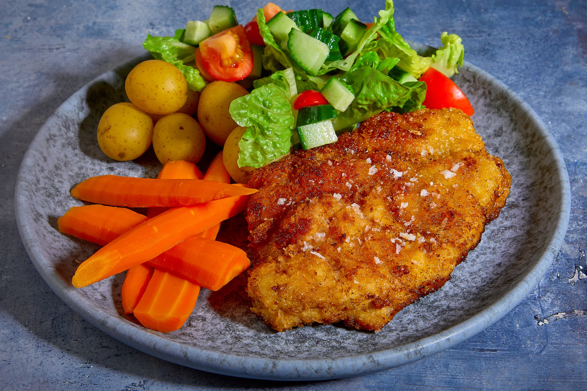 Paneret kotelet med kartofler, smørdampede gulerødder og grøn salat