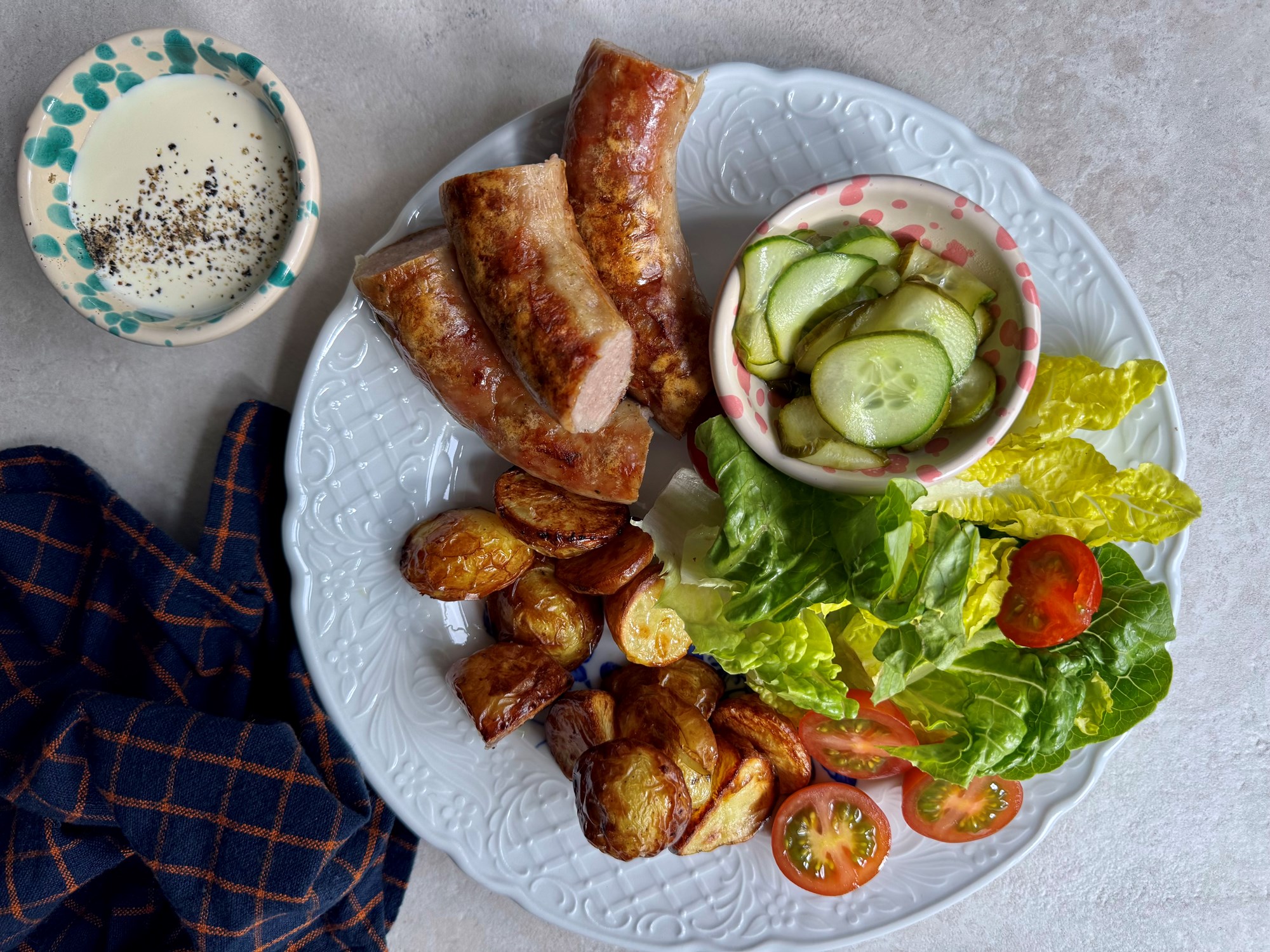 Medisterpølse med agurkesalat, stegte kartofler og salat