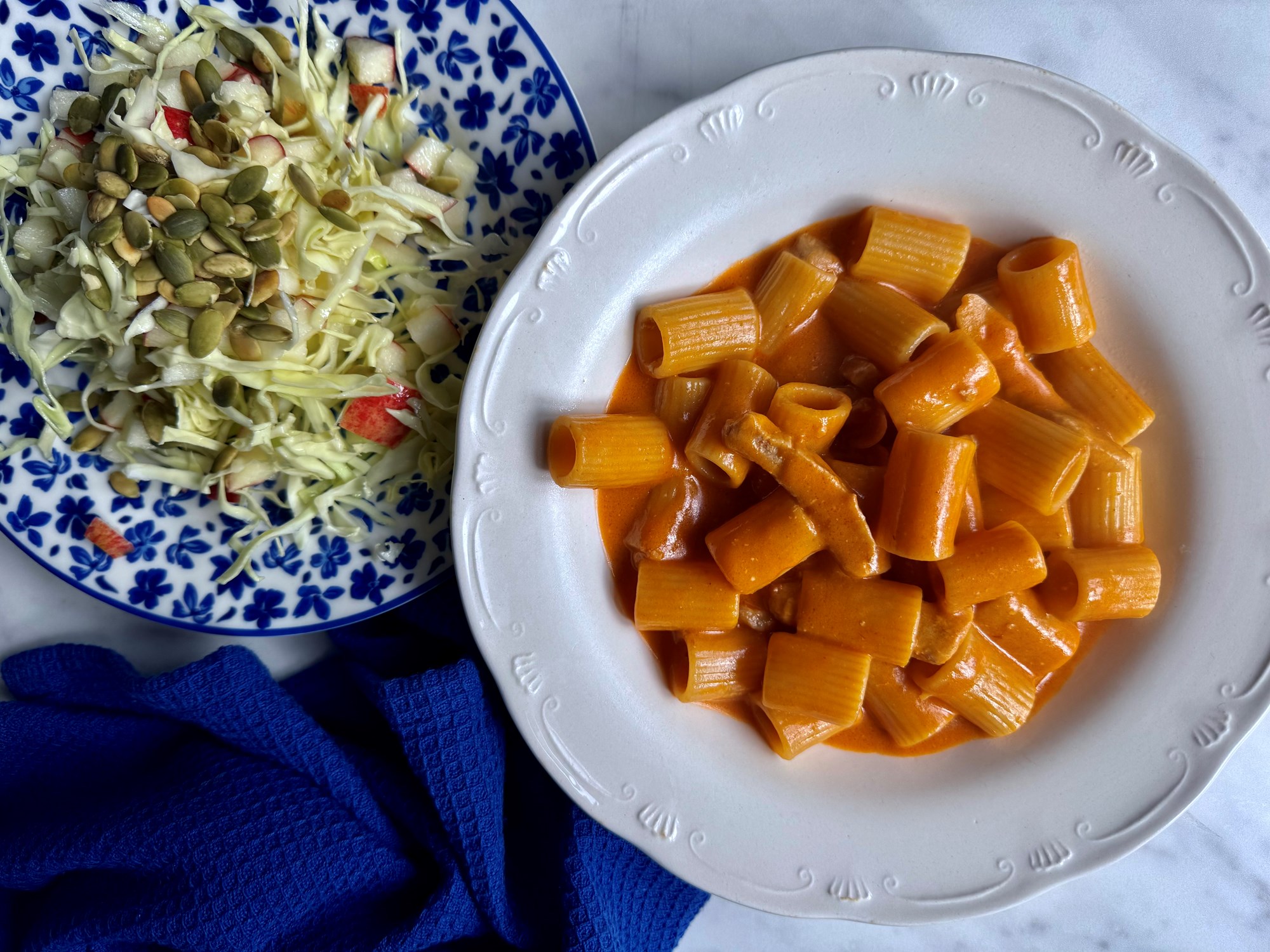 Gris og pasta i cremet tomatsauce og kålsalat med æble