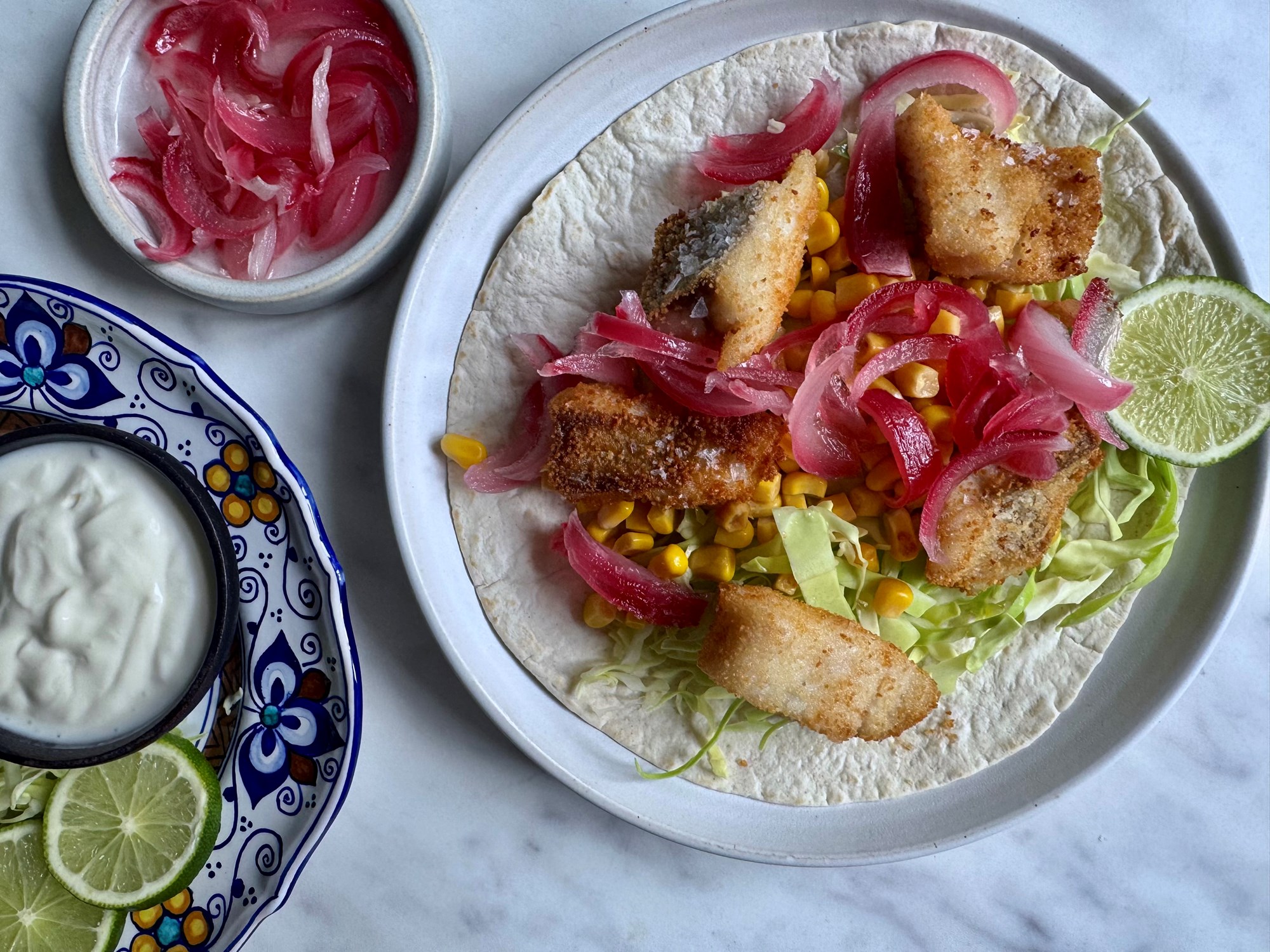 Fish tacos med majs, creme fraiche og syltede løg