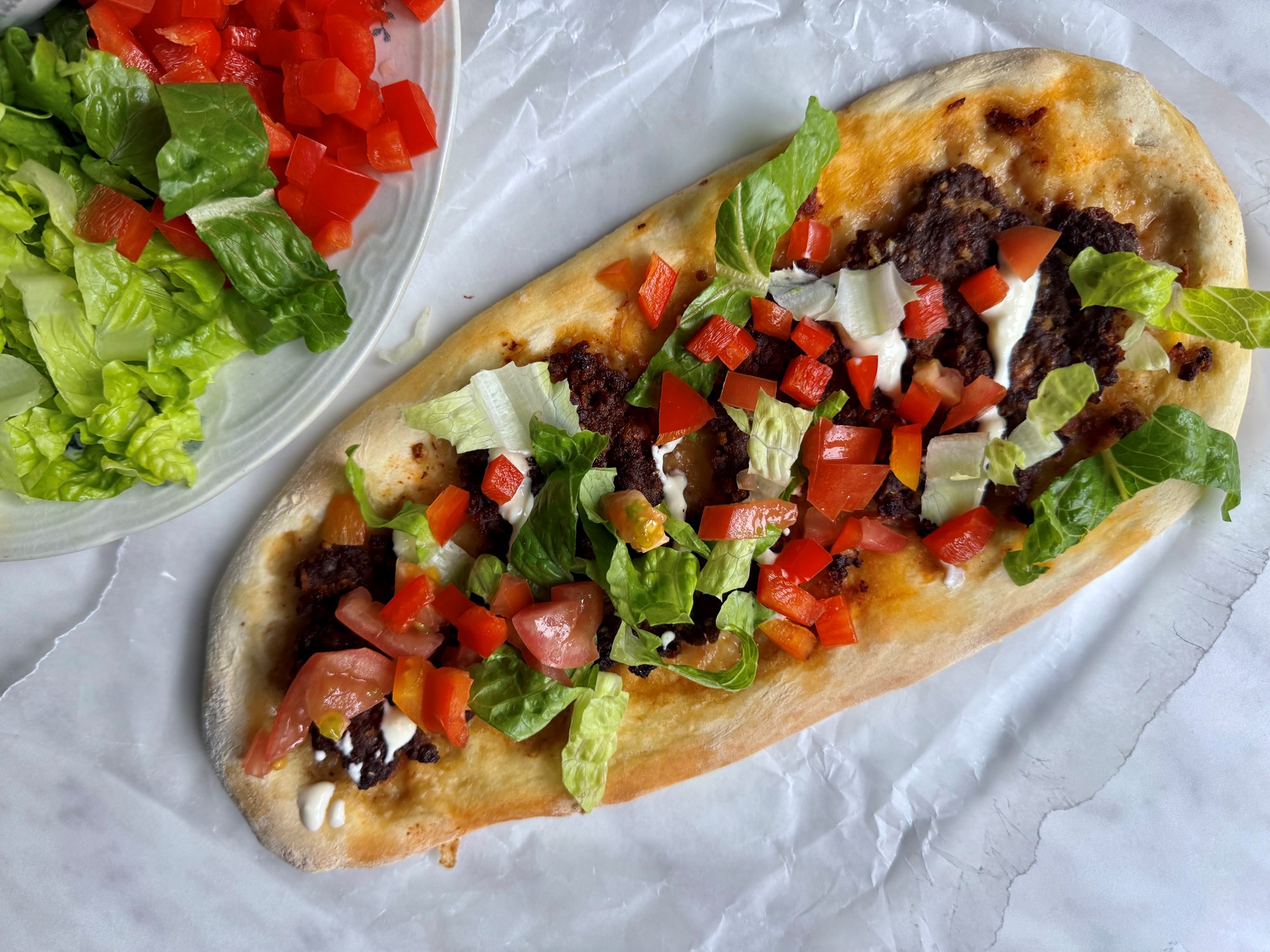 Lahmacun med krydret oksekød, salat og hvidløgsdressing