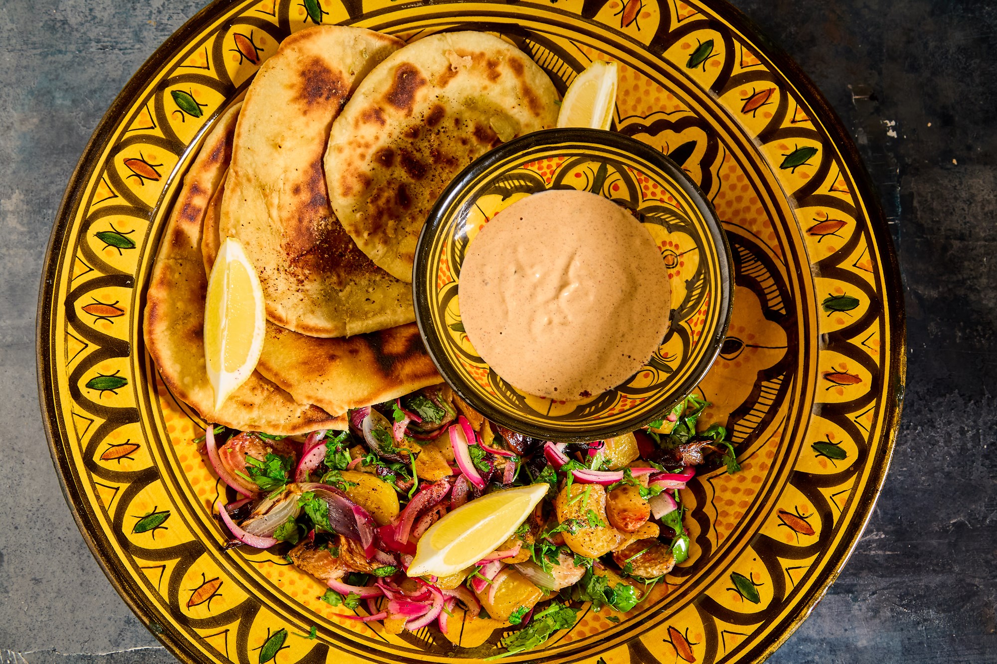 Bolchebeder og rødløg med tahin-harissayoghurt, persille og pandestegte fladbrød