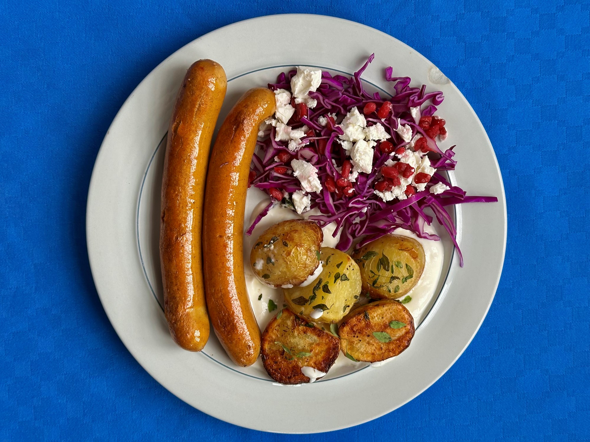 Pølser med frisk kålsalat, granatæble og kota