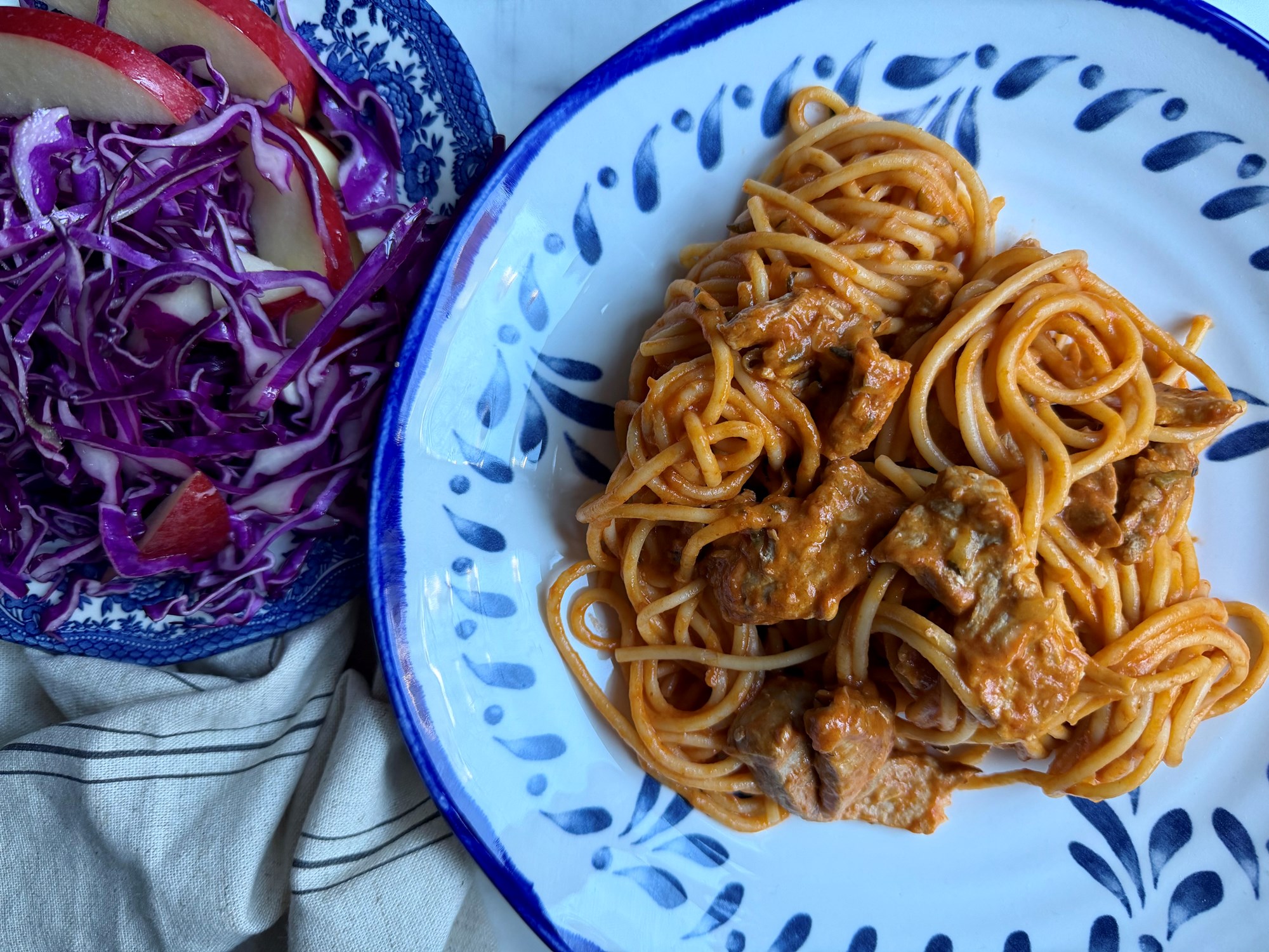 Spaghetti og gris i cremet tomatsauce og kålsalat med æble