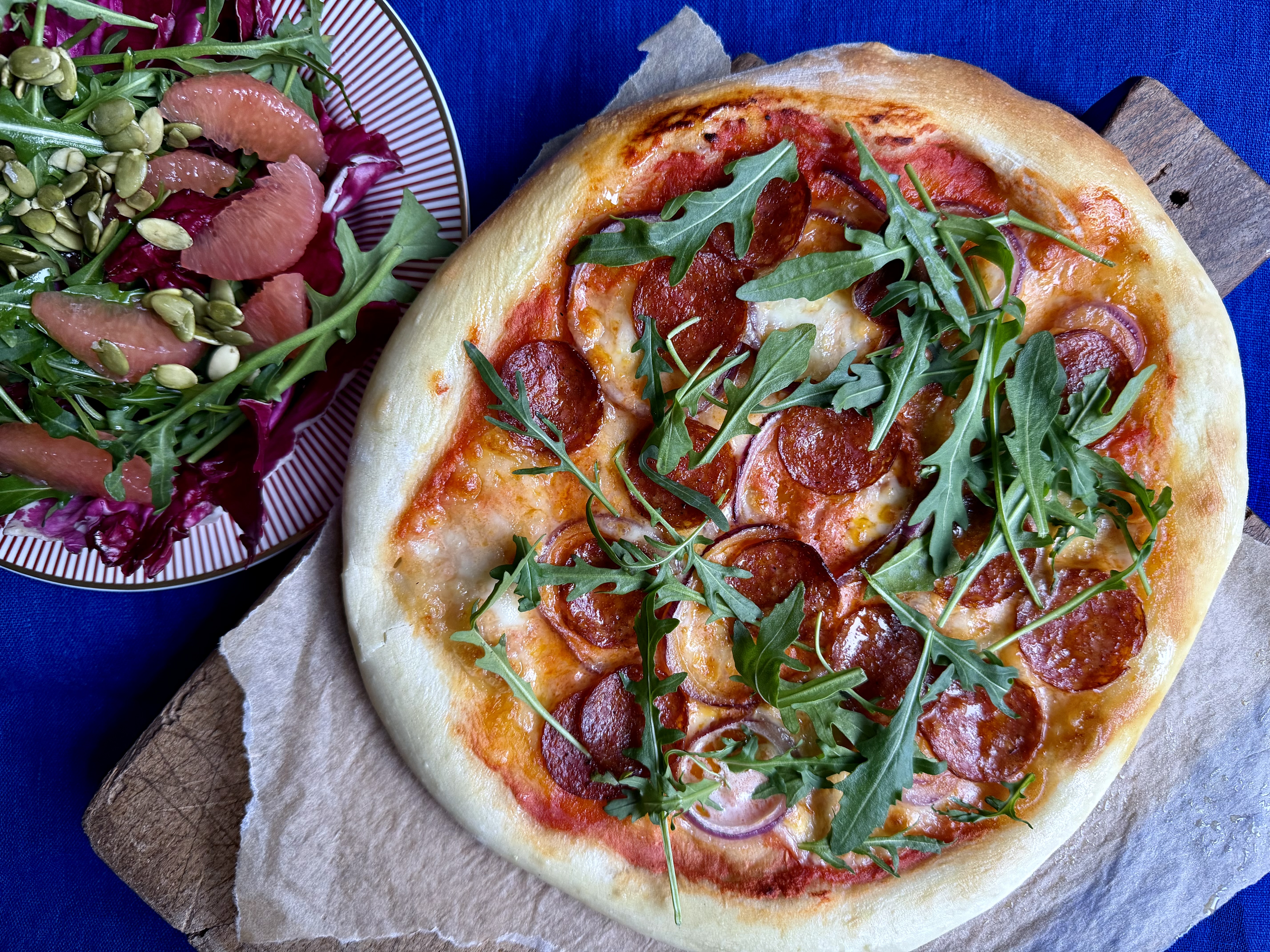 Pizza med pepperoni, mozzarella og salat og bittersalat med grape