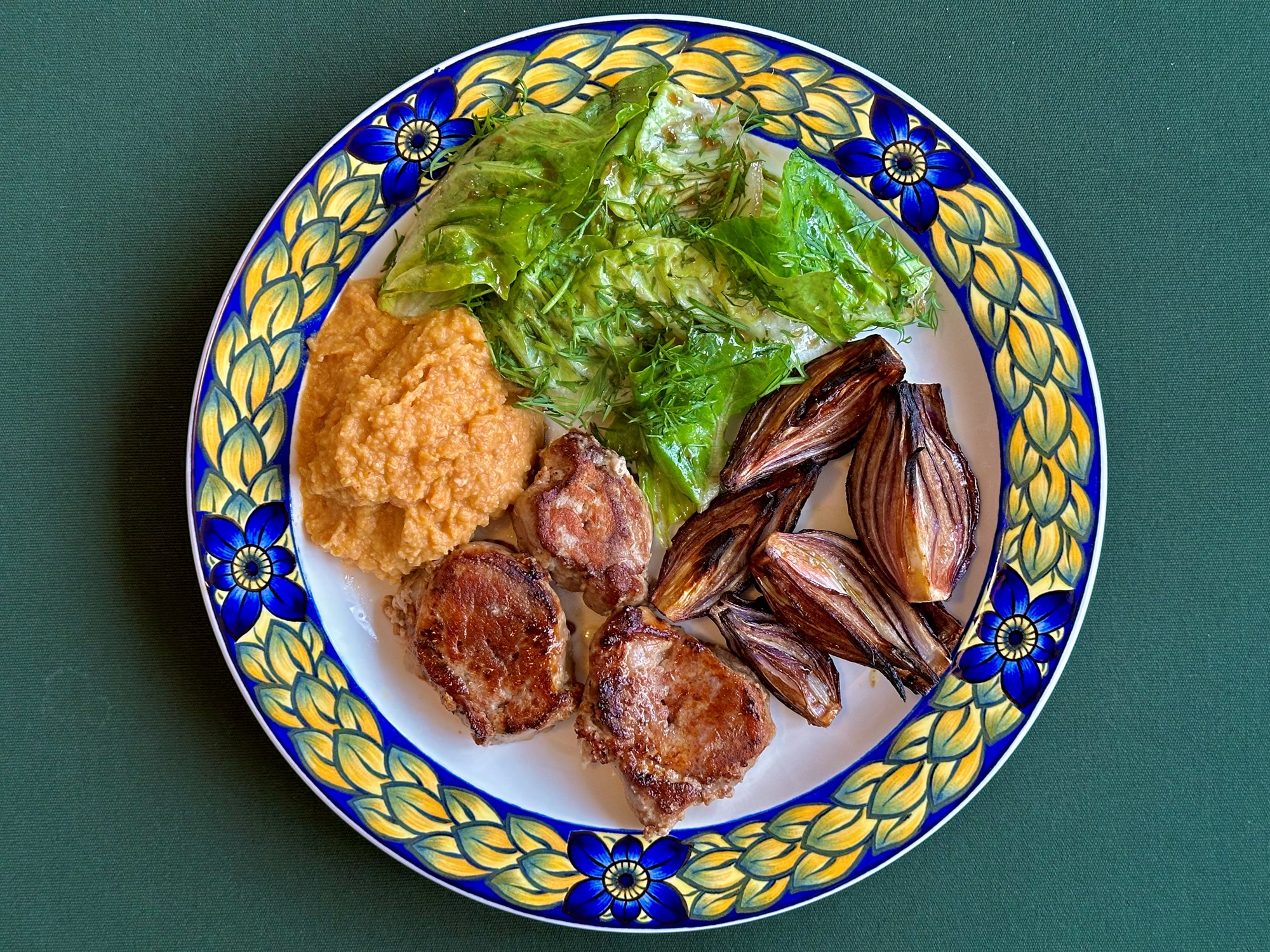 Stegt mørbrad med grillede løg, humus og grøn salat