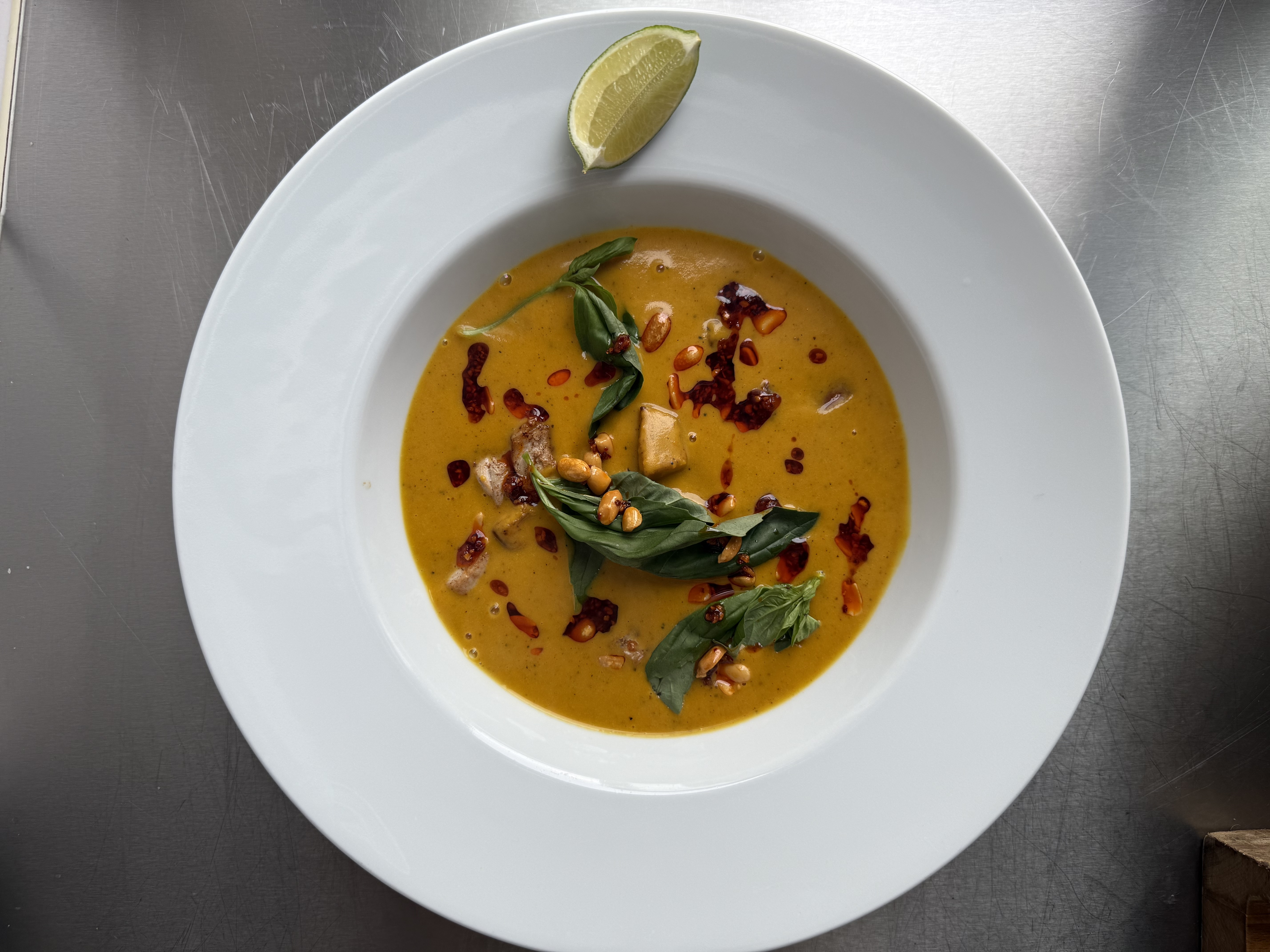 Græskarsuppe med sprød gris, peanut-chili olie og lime