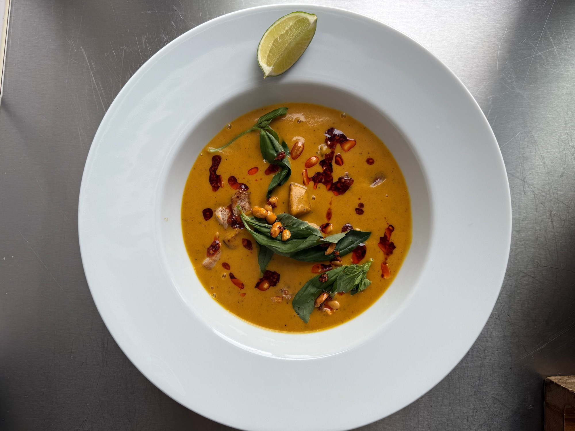 Græskarsuppe med sprød gris, peanut-chili olie og lime