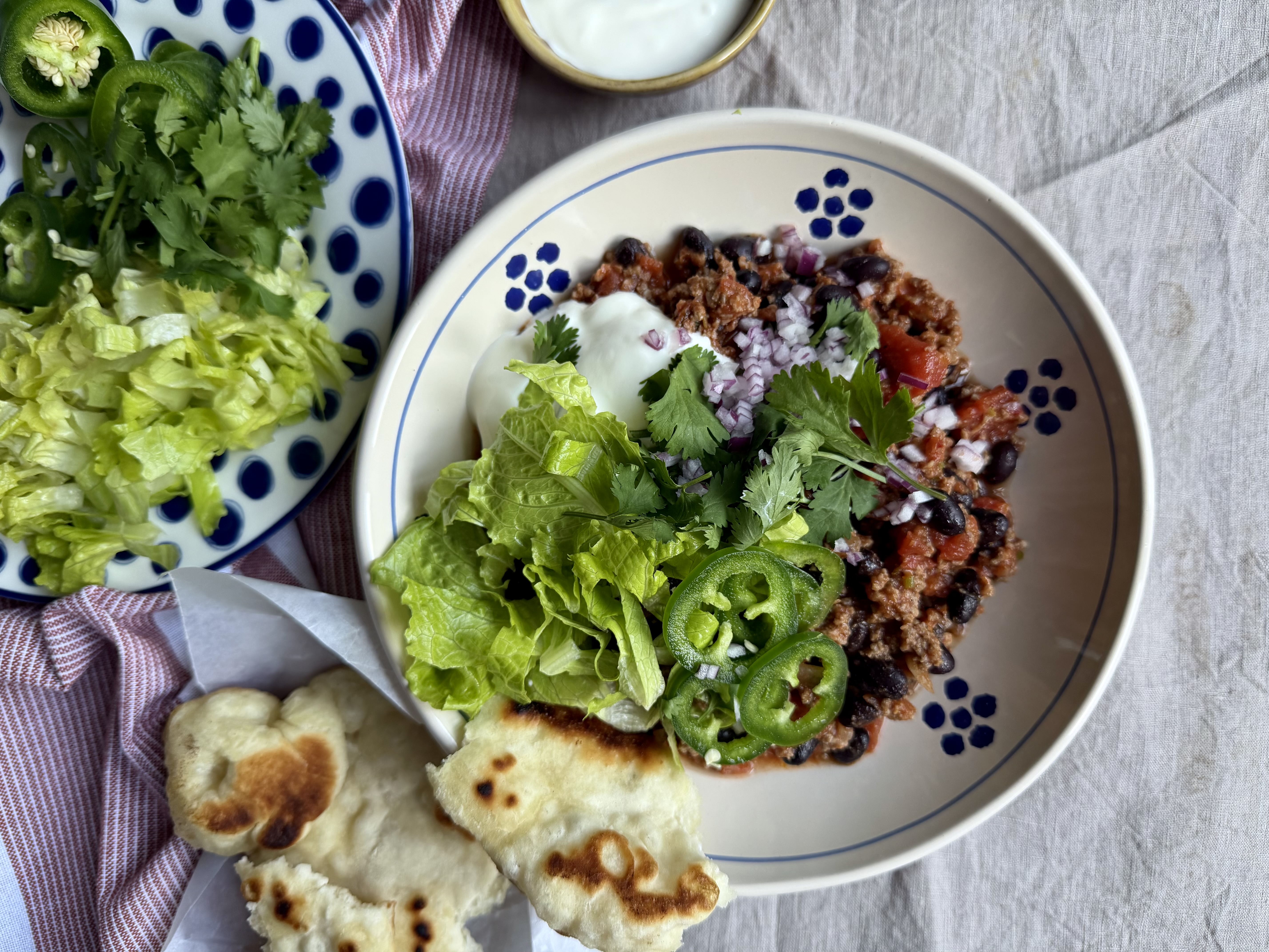 Hurtig chili con carne med salat, koriander og lune pandebrød