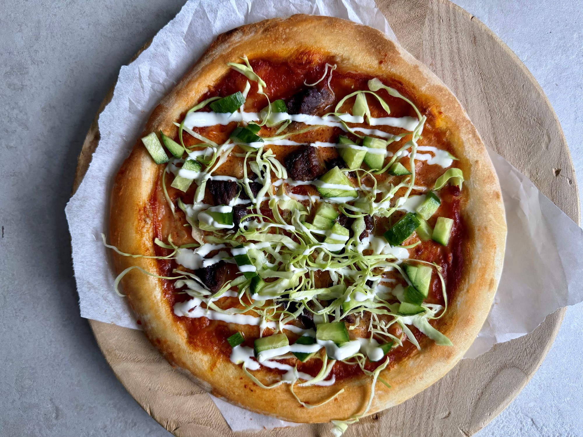 Pizza med strimler af oksekød, sprøde grøntsager og hvidløgsdressing