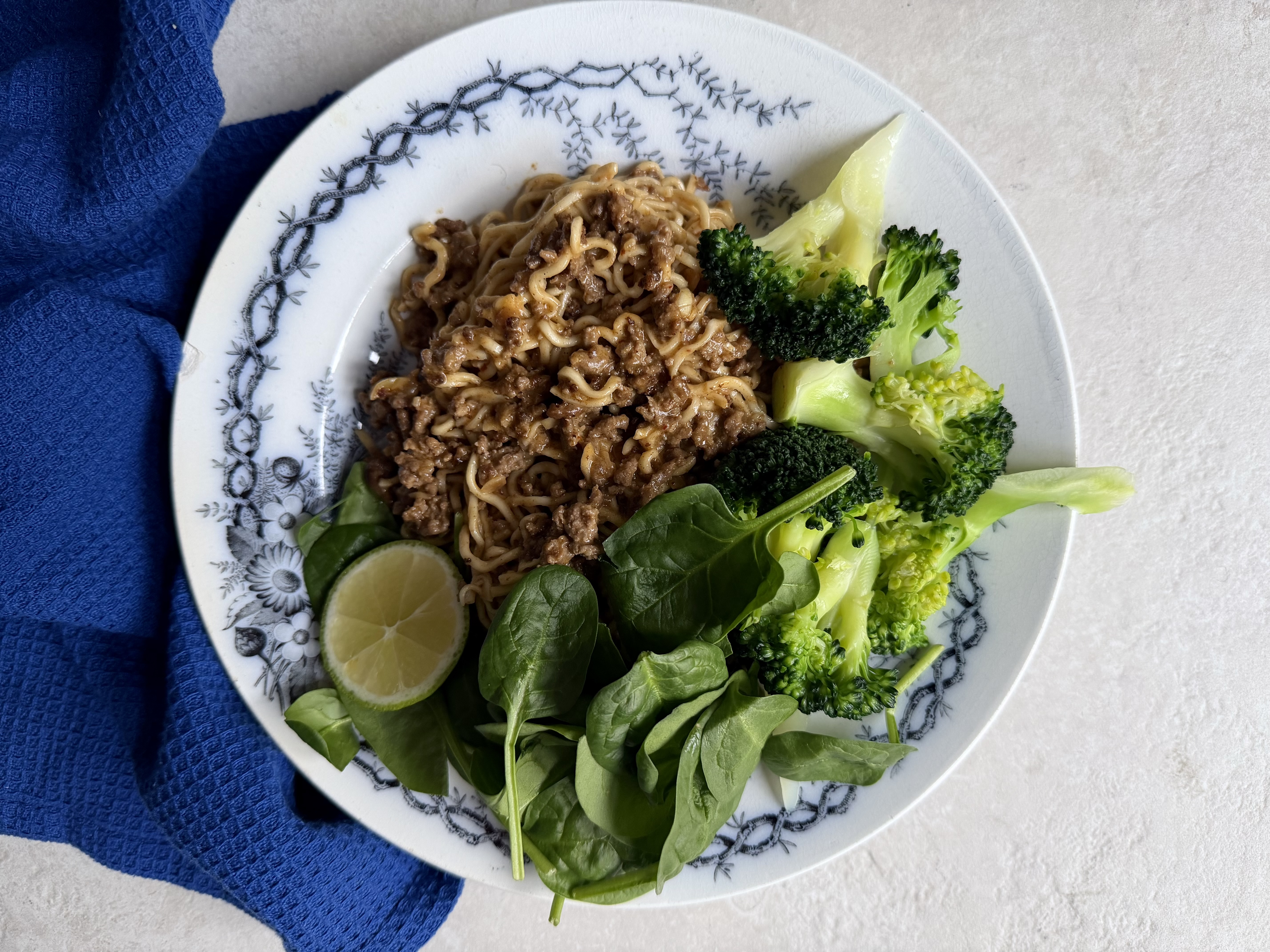 Nudler med krydret oksekød, peanutsauce og broccoli