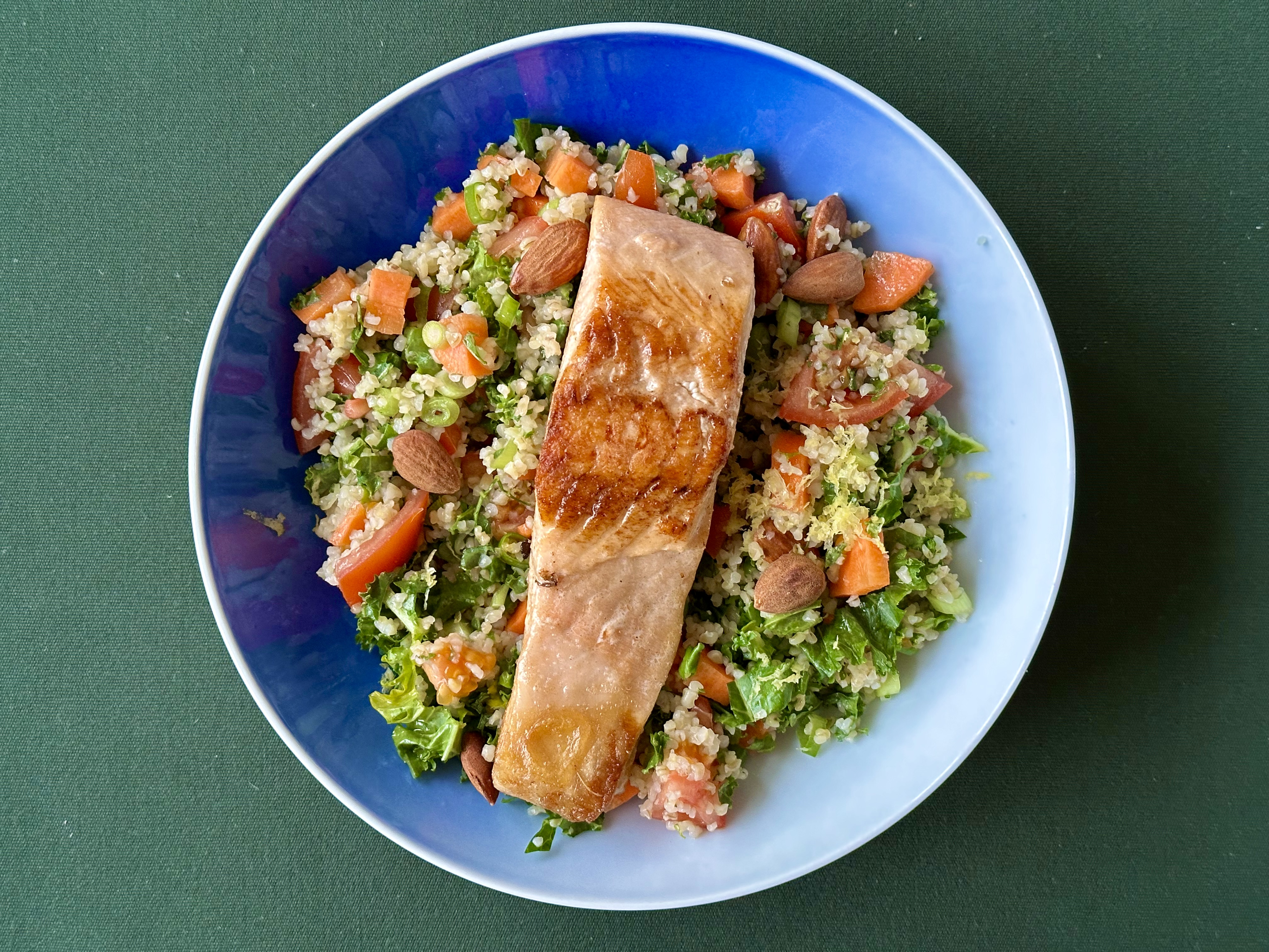 Laks i urtebulgur med mandler, tomat og forårsløg