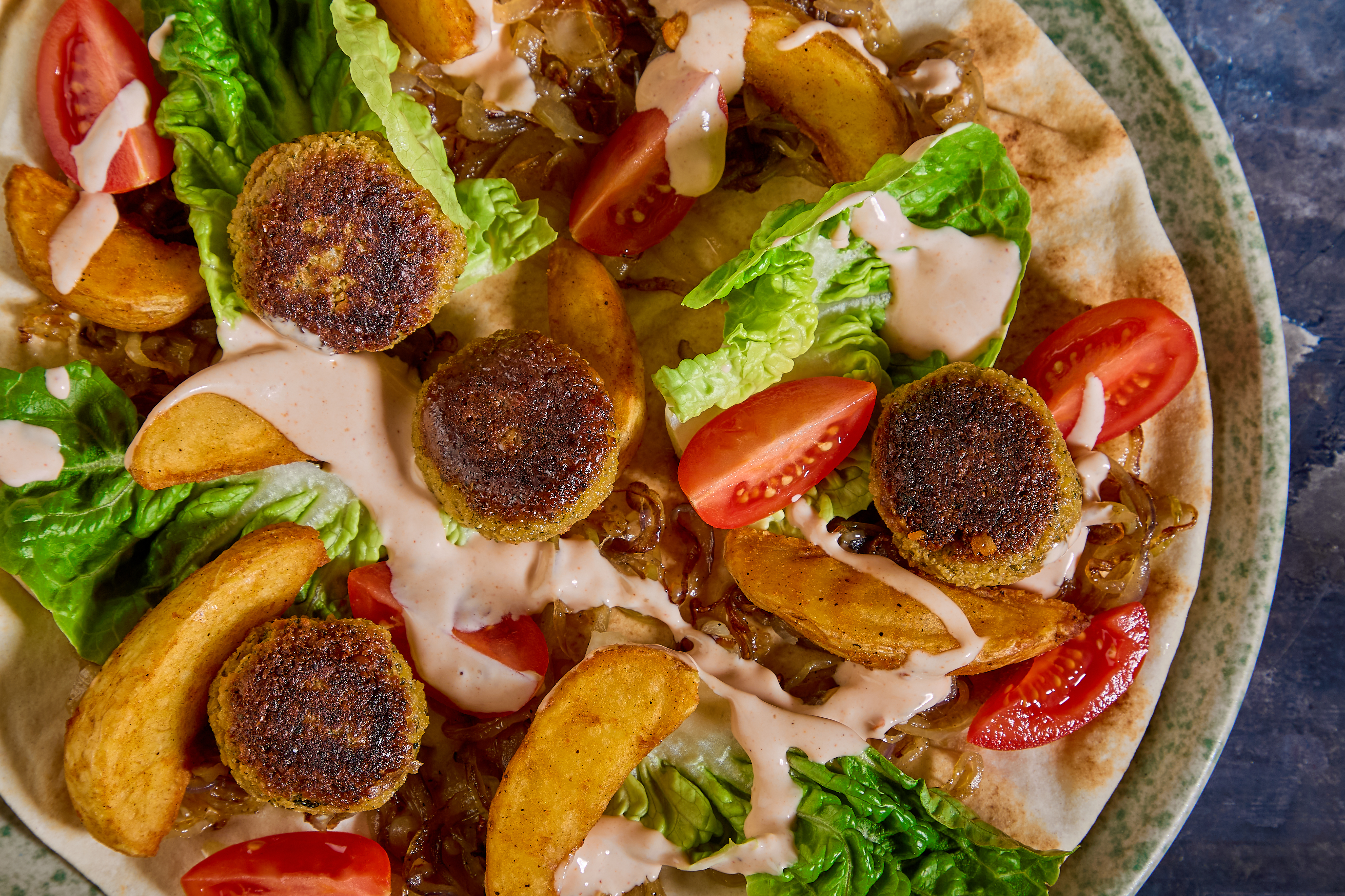 Fladbrød med falafel, karamelliserede løg, chipotle-dressing og sprød salat