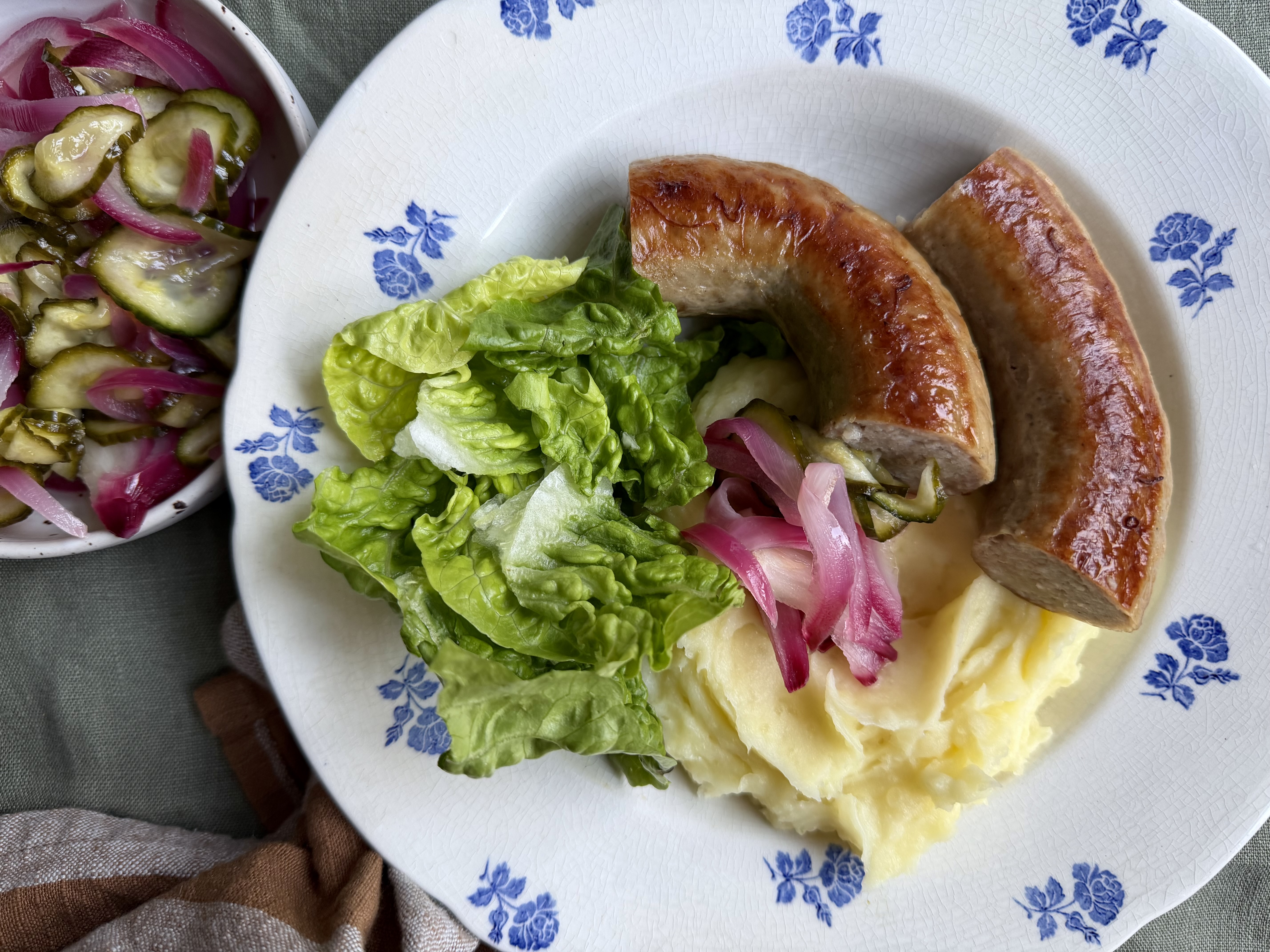 Medister med agurkesalat, kartoffelmos og grøn salat