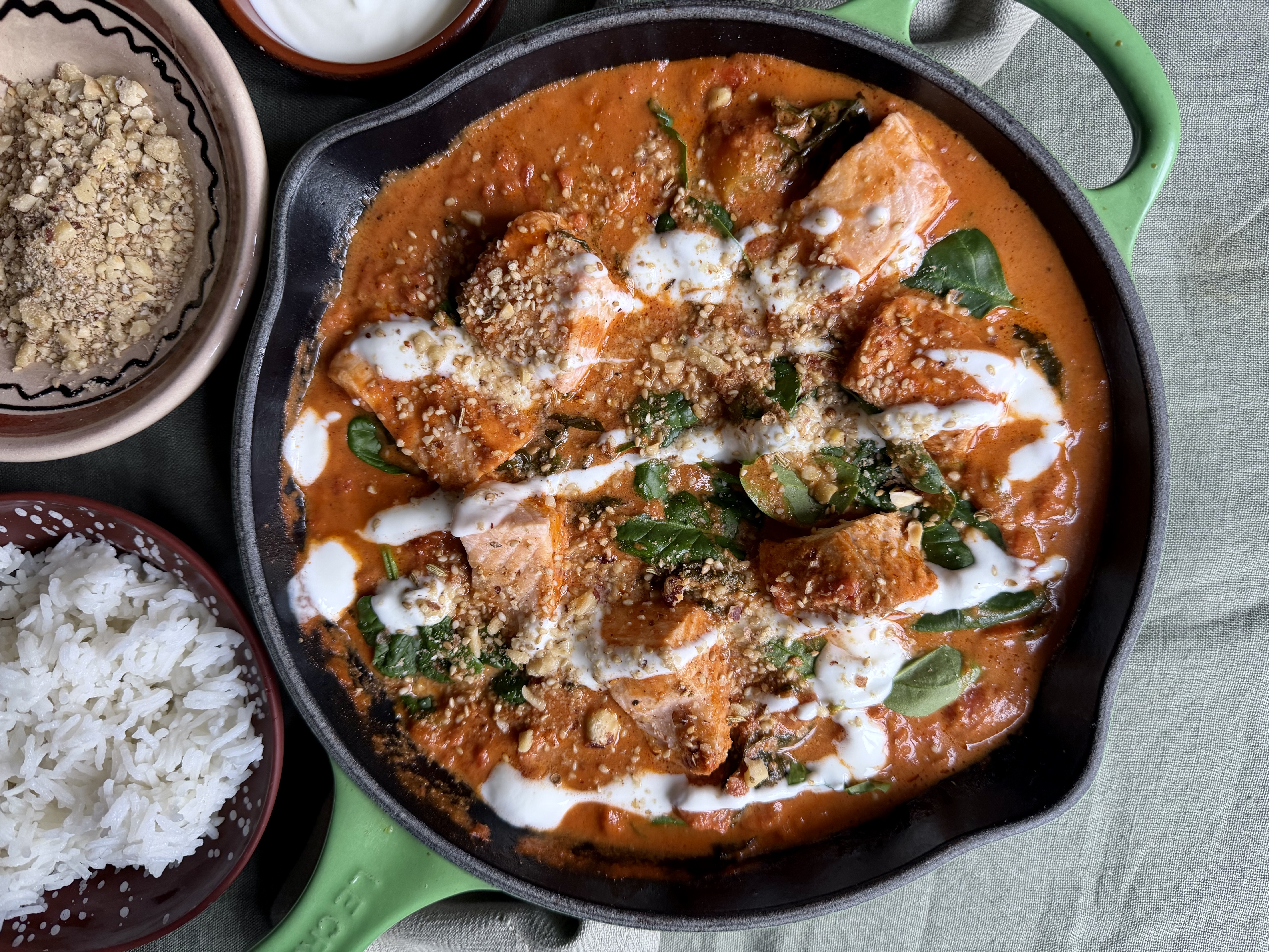 Laks i spicy, cremet tomatsauce med dukkah og spinat