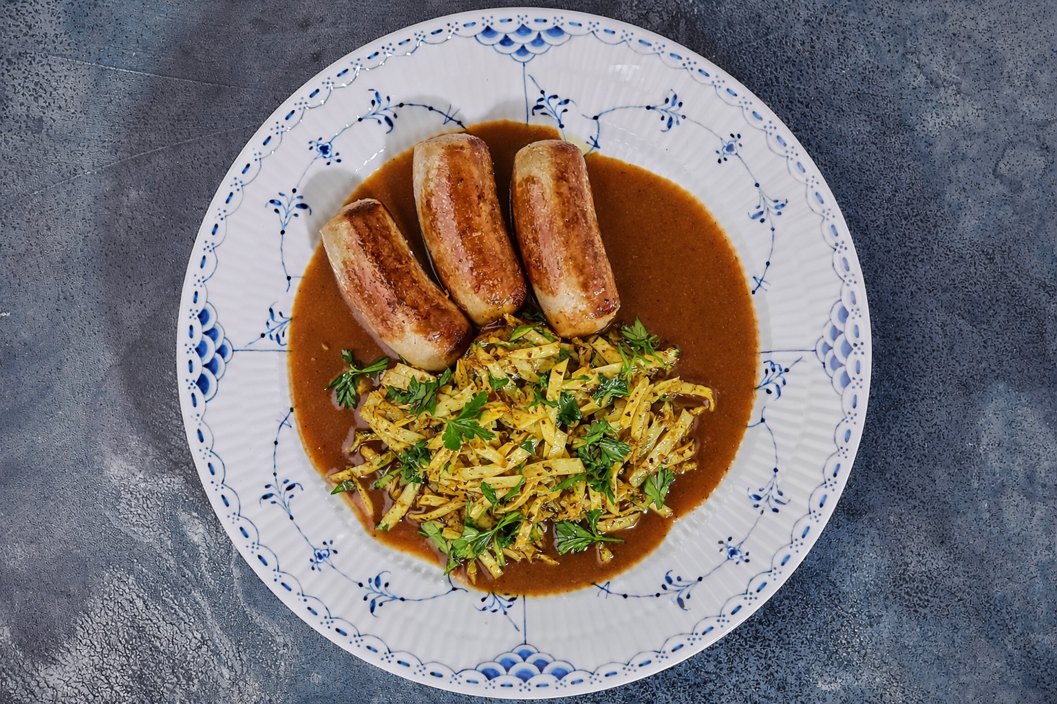 Medister med stegt spidskål, kartofler og skysovs