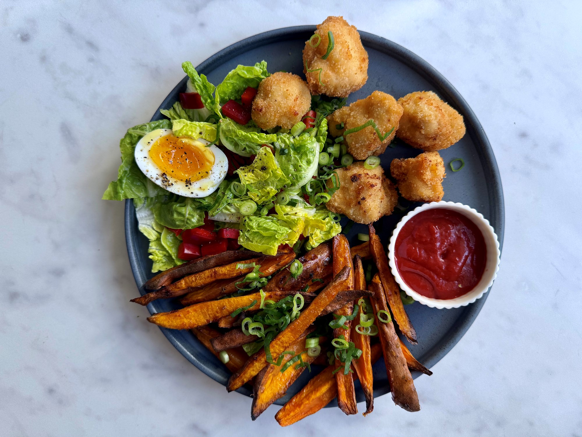 Kyllingenuggets med søde kartofler og grøn salat med æg