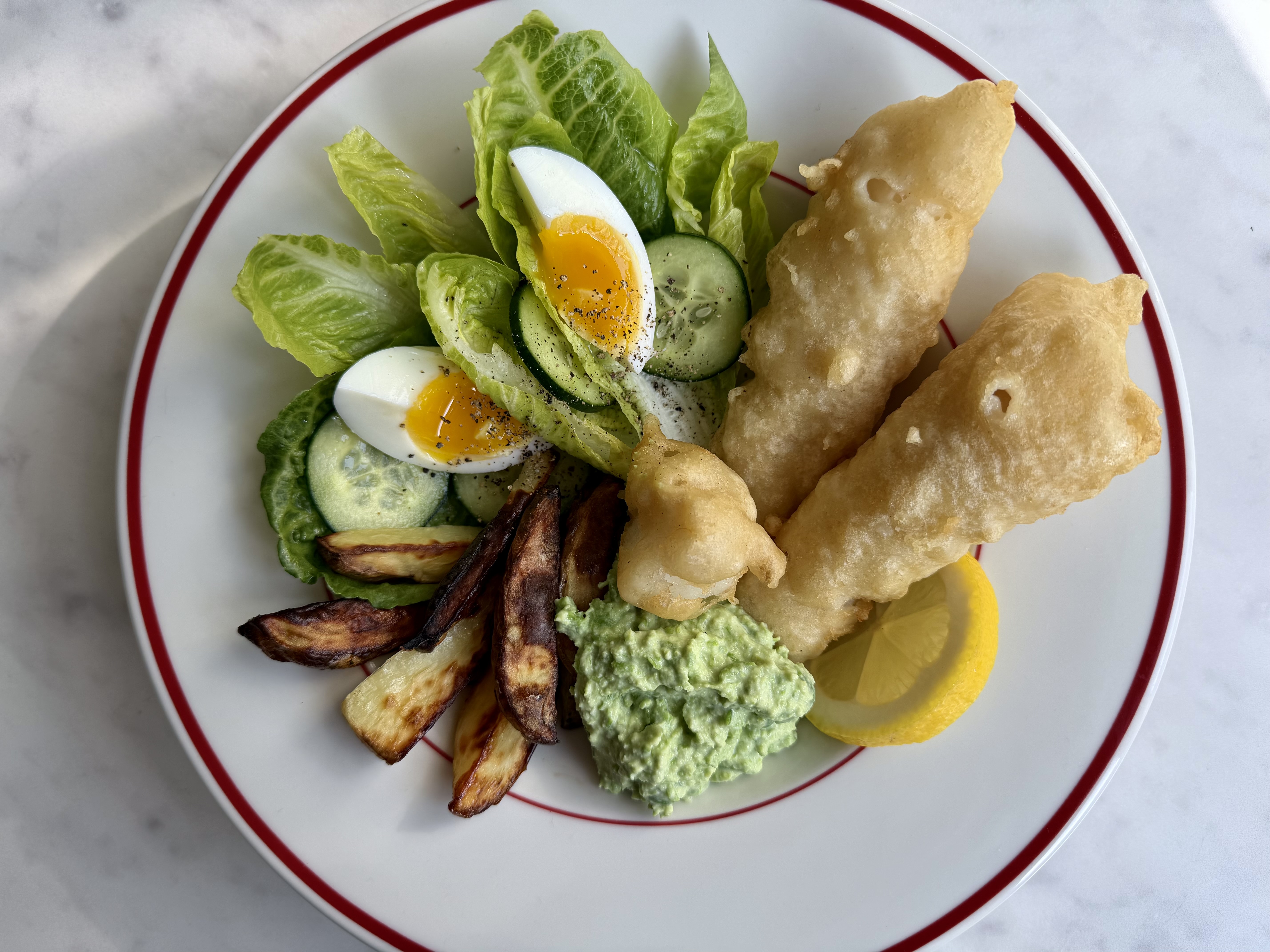 Fish and chips med ærtemos og grøn salat med smilende æg