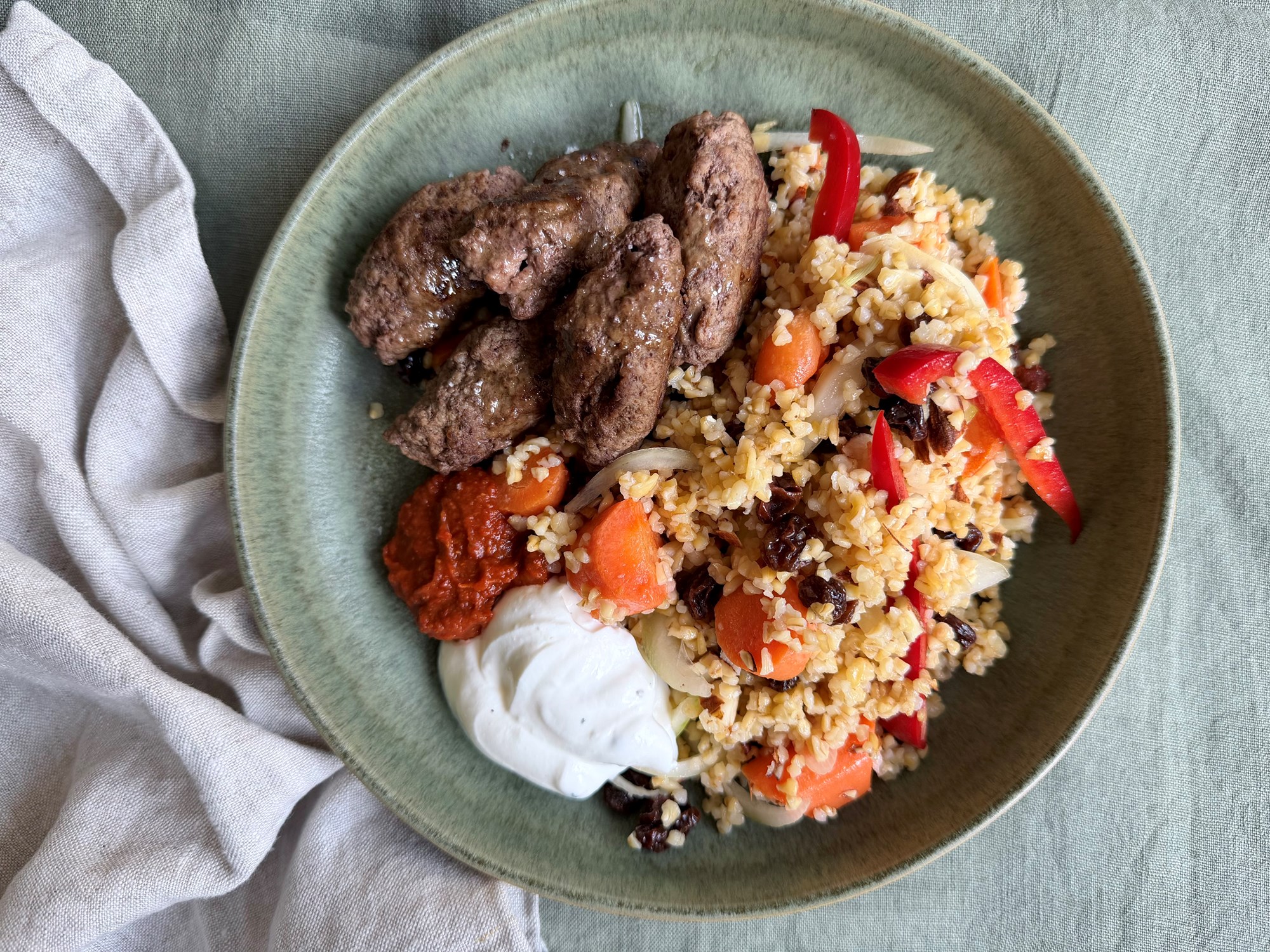 Kebab og bulgursalat med mandler, rosiner og sprøde grøntsager