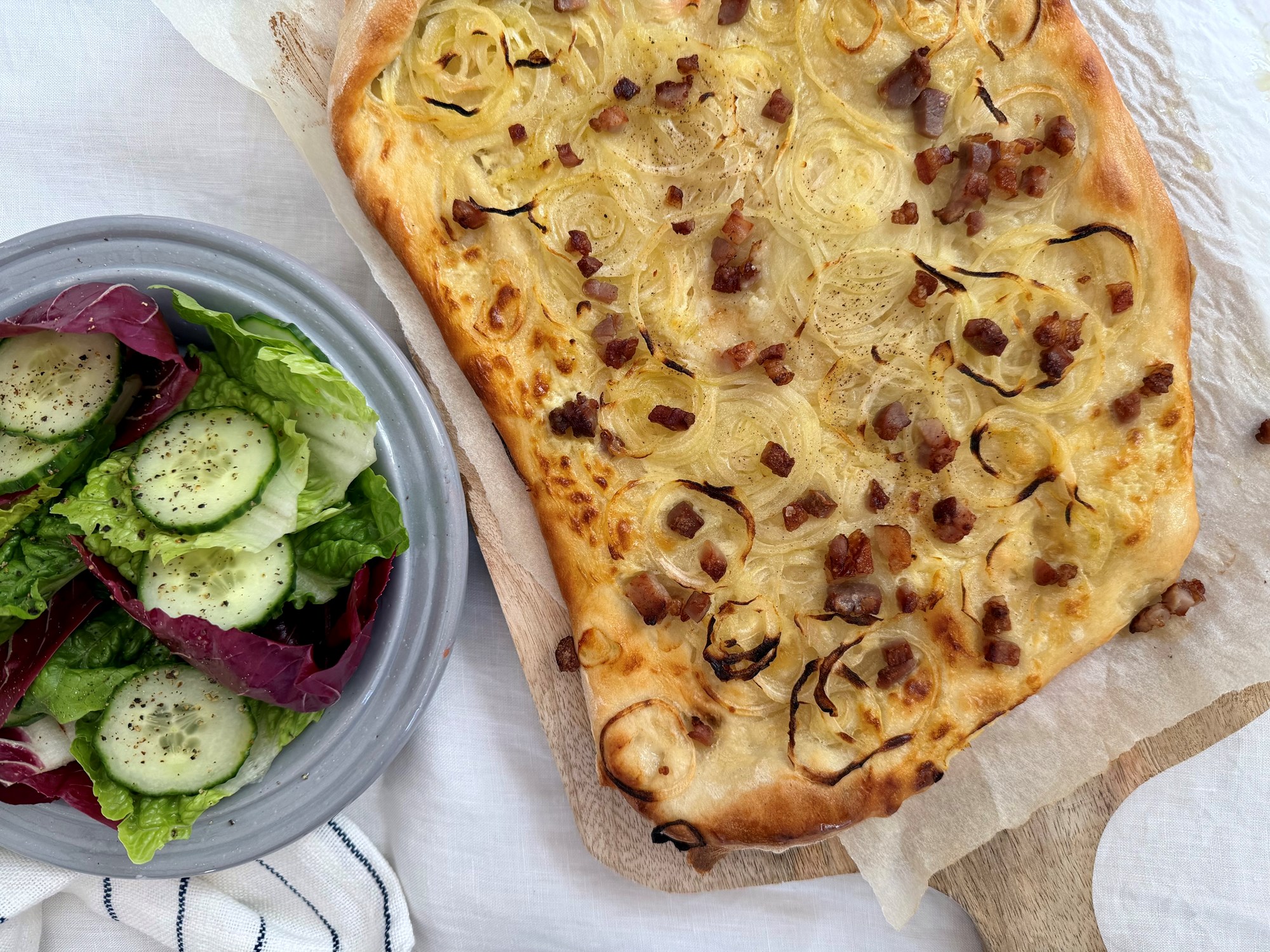 Løg-pizza med creme fraiche & bacon og salat med agurk