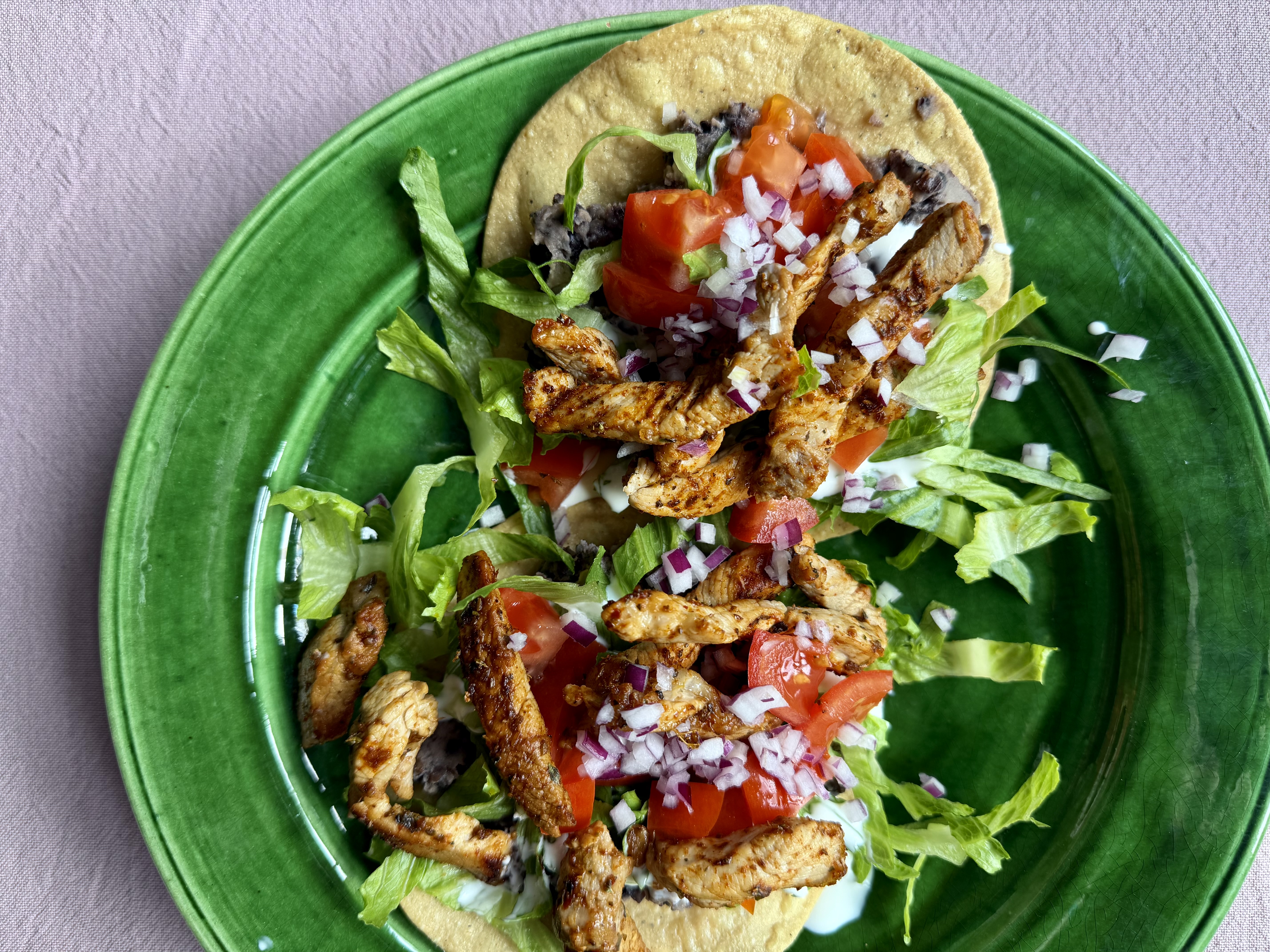 Tostadas med strimler af gris, salat og bønner