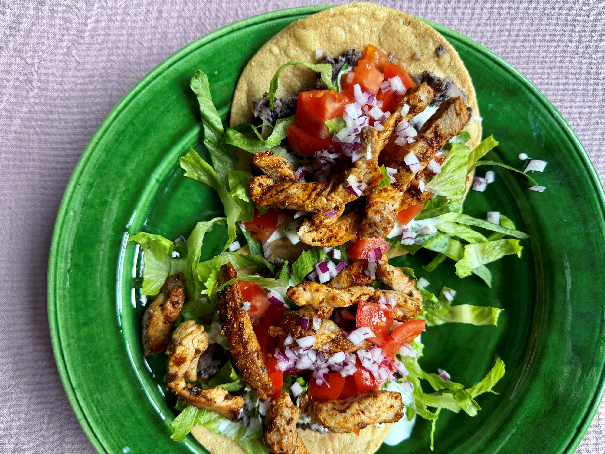 Tostadas med strimler af gris, salat og bønner