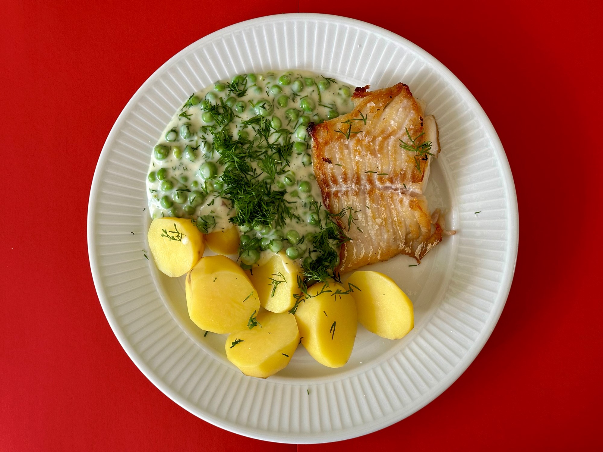 Hvidløgstegt torsk med stuvede ærter og dild
