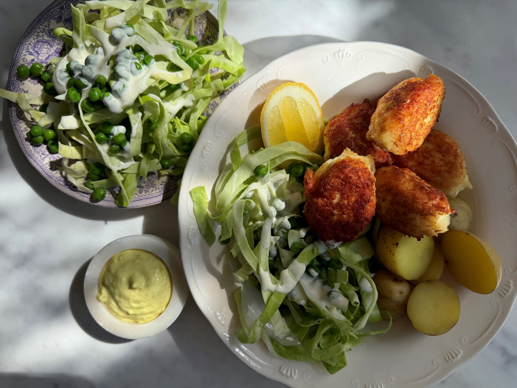 Fiskefrikadeller med kartofler, spidskål og lune ærter med mormordressing