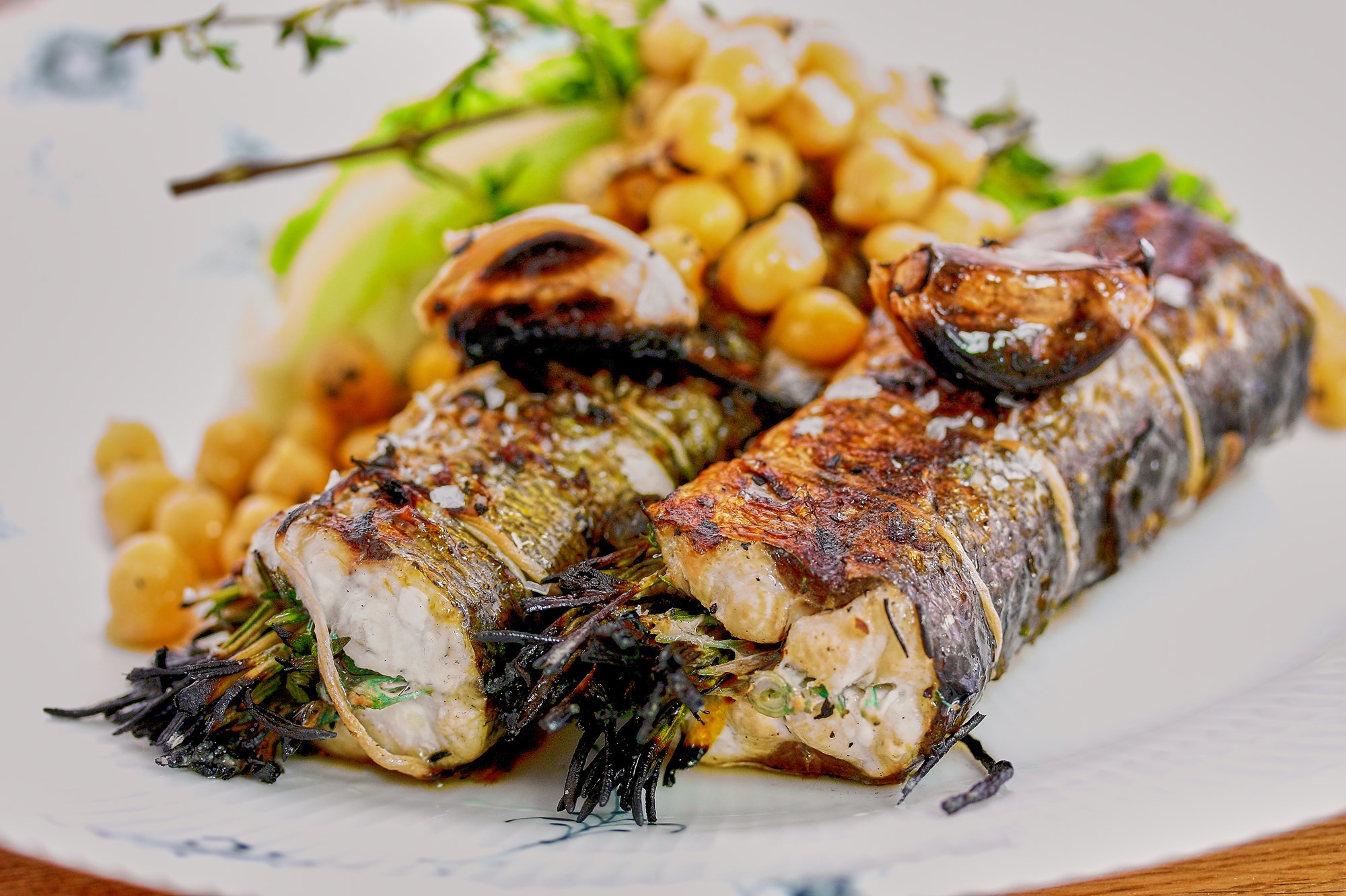 Grillet hel hornfisk med rosmarin og timian serveret med spidskål og kikærter