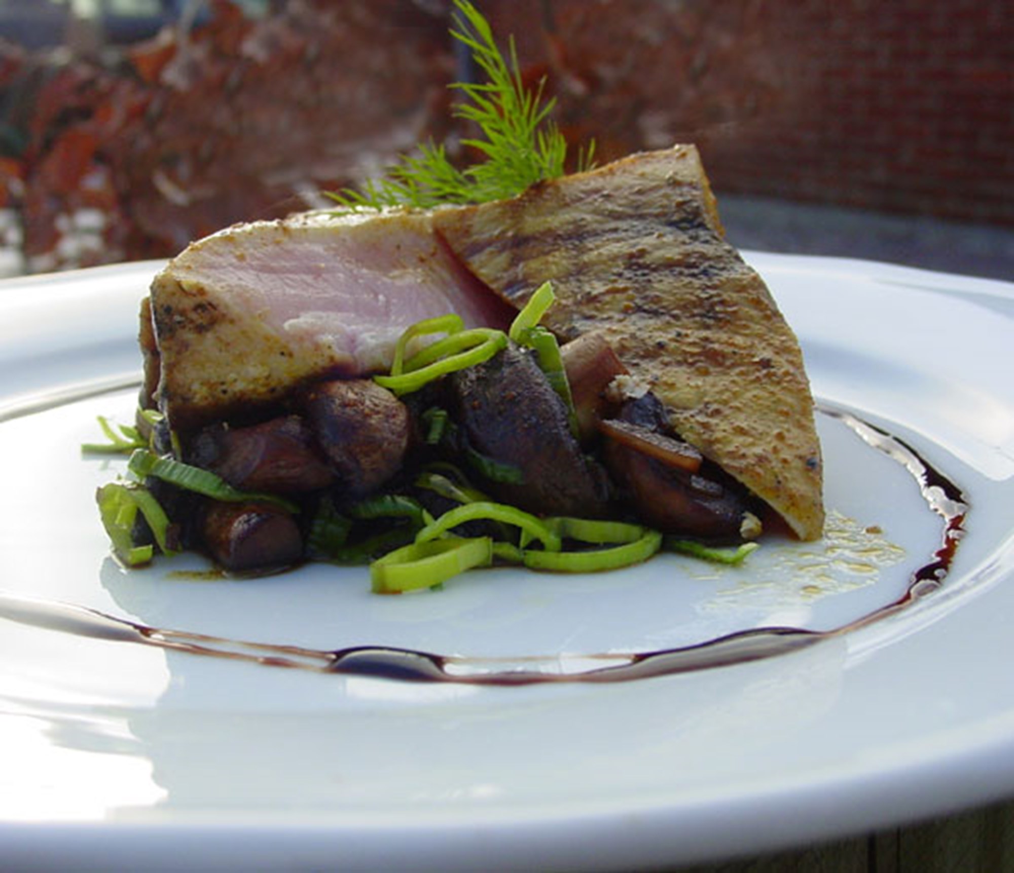 Sværdfiskesteaks på bund af sojamarinerede svampe og bønner serveret med jordskokkesauté og hønseglace