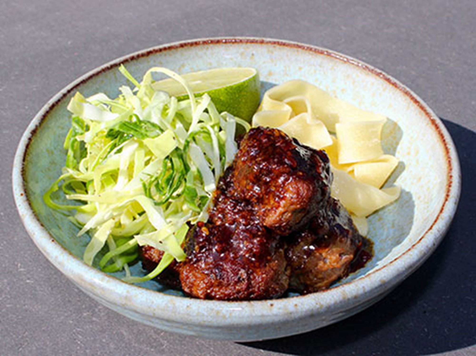 Asiatiske kødboller med teriyaki, pasta, rå sommerkål og lime