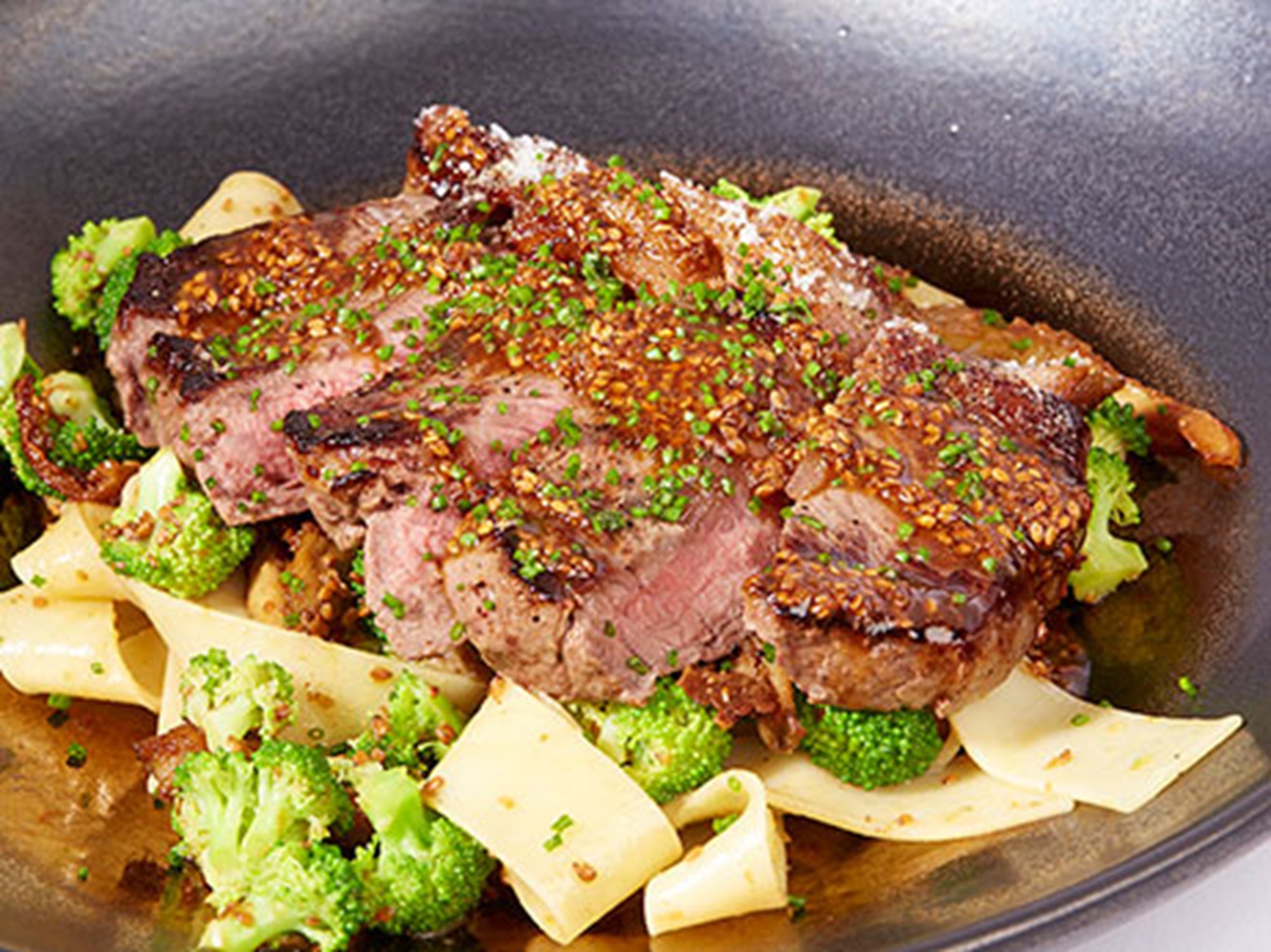 Steak med pappardelle, svampe, broccoli og goma dressing