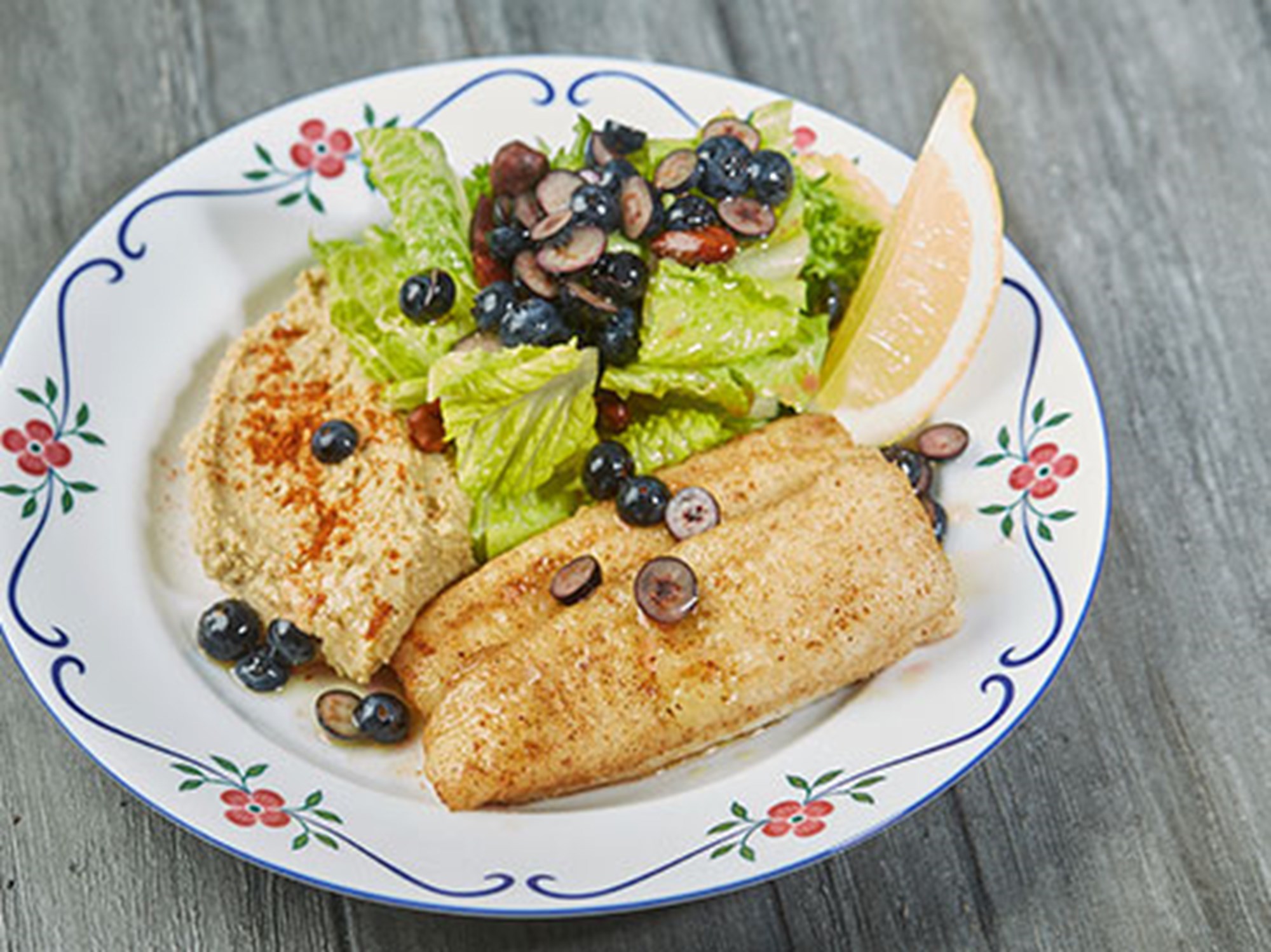 Stegt filet af skærising med humus, batavia-salat med saltmandler og blåbær
