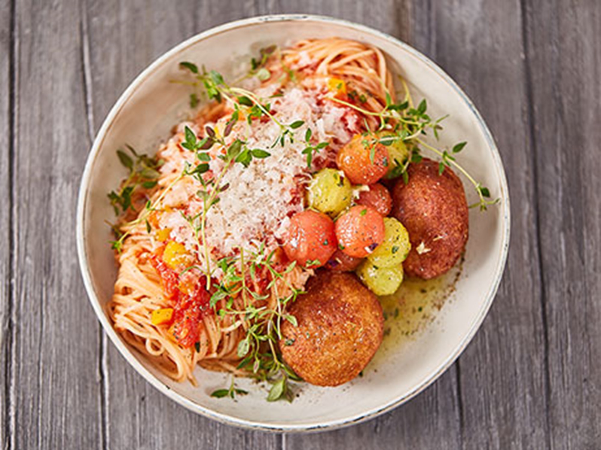 Fiskefrikadeller med spaghetti, zucchini, peberfrugt og lyn-syltede tomater