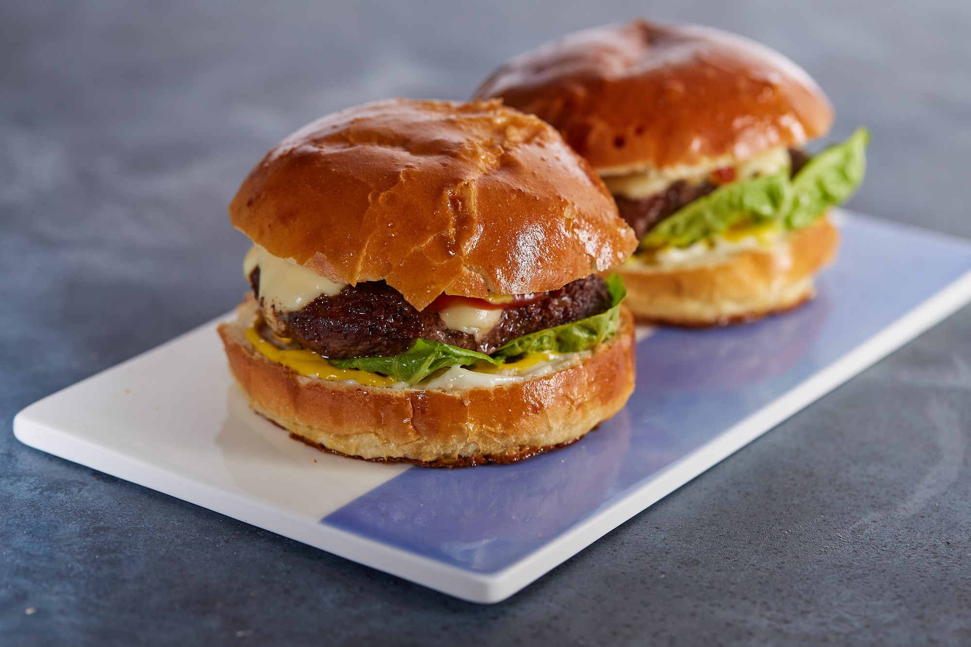 Klassisk US style burger i brioche med dildpickles og sriracha og stegte kartofler