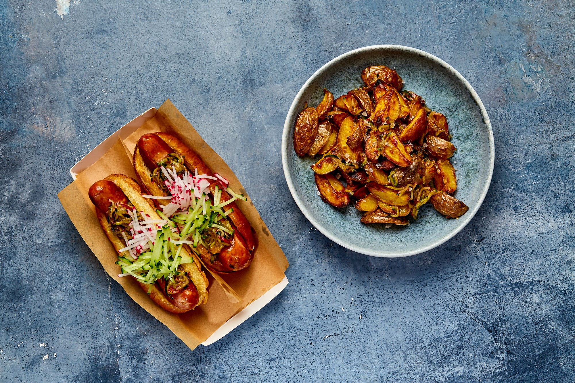 Hotdogs med ostegrillpølser fra Bodebjerg og brioche dertil stegte kartofler i tomatrelish med agurk og radise