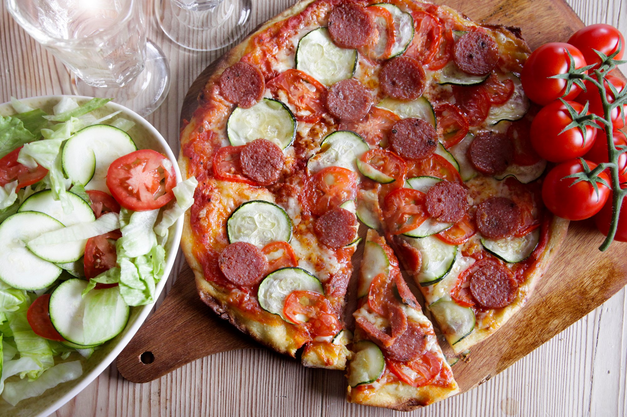 Pizza med salami ventrizina, tomater, courgetter og grøn salat.