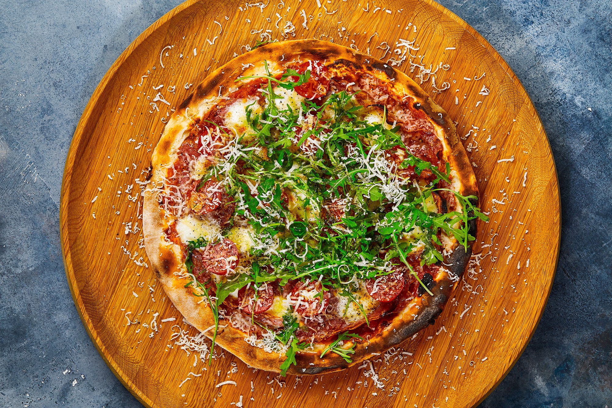 Pizza med salame Cacciatore, saltede tomater, mozzarella og rucola