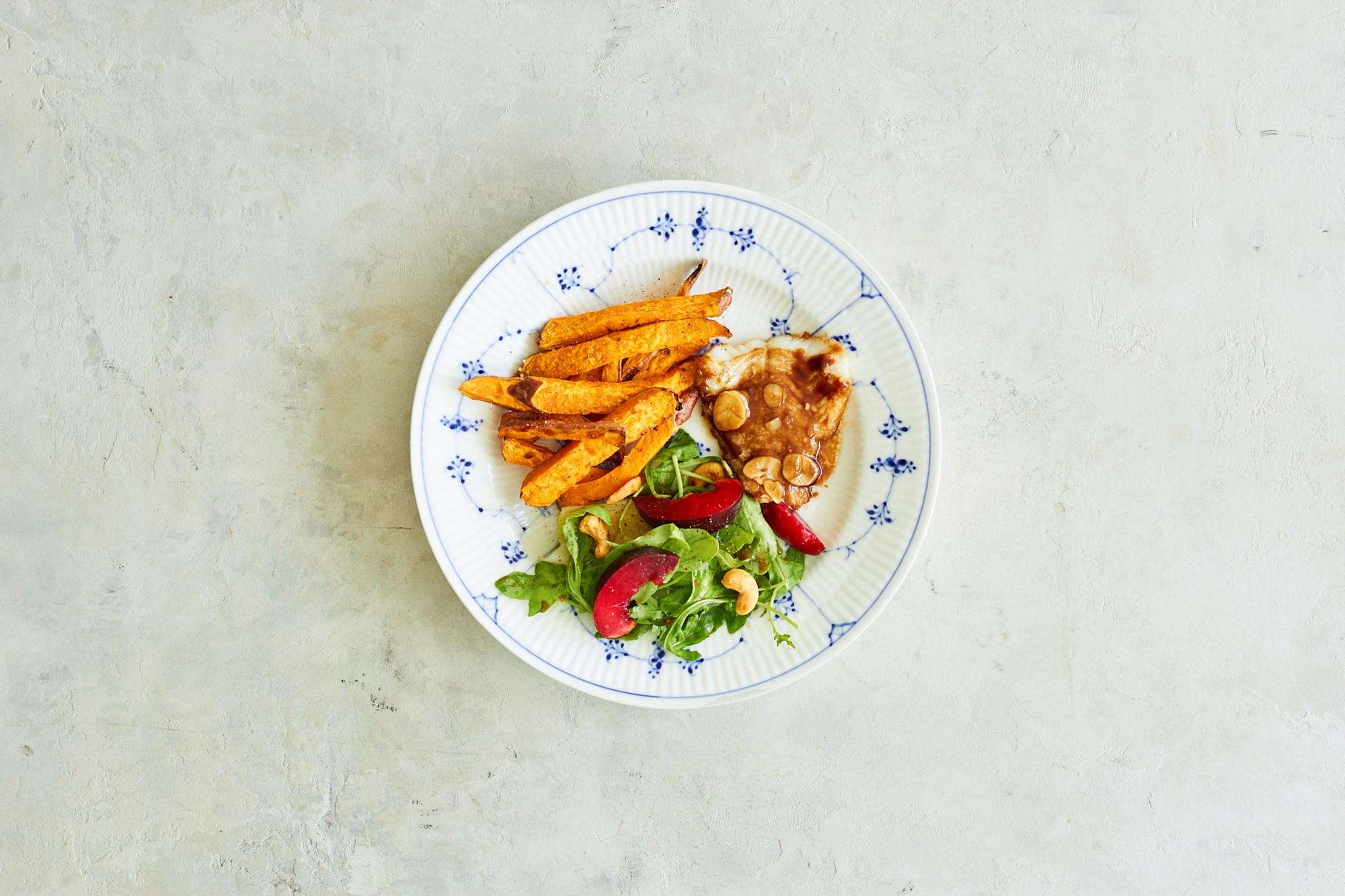 Hoisinstegt torsk med salat på rucola, porrer og nye blommer