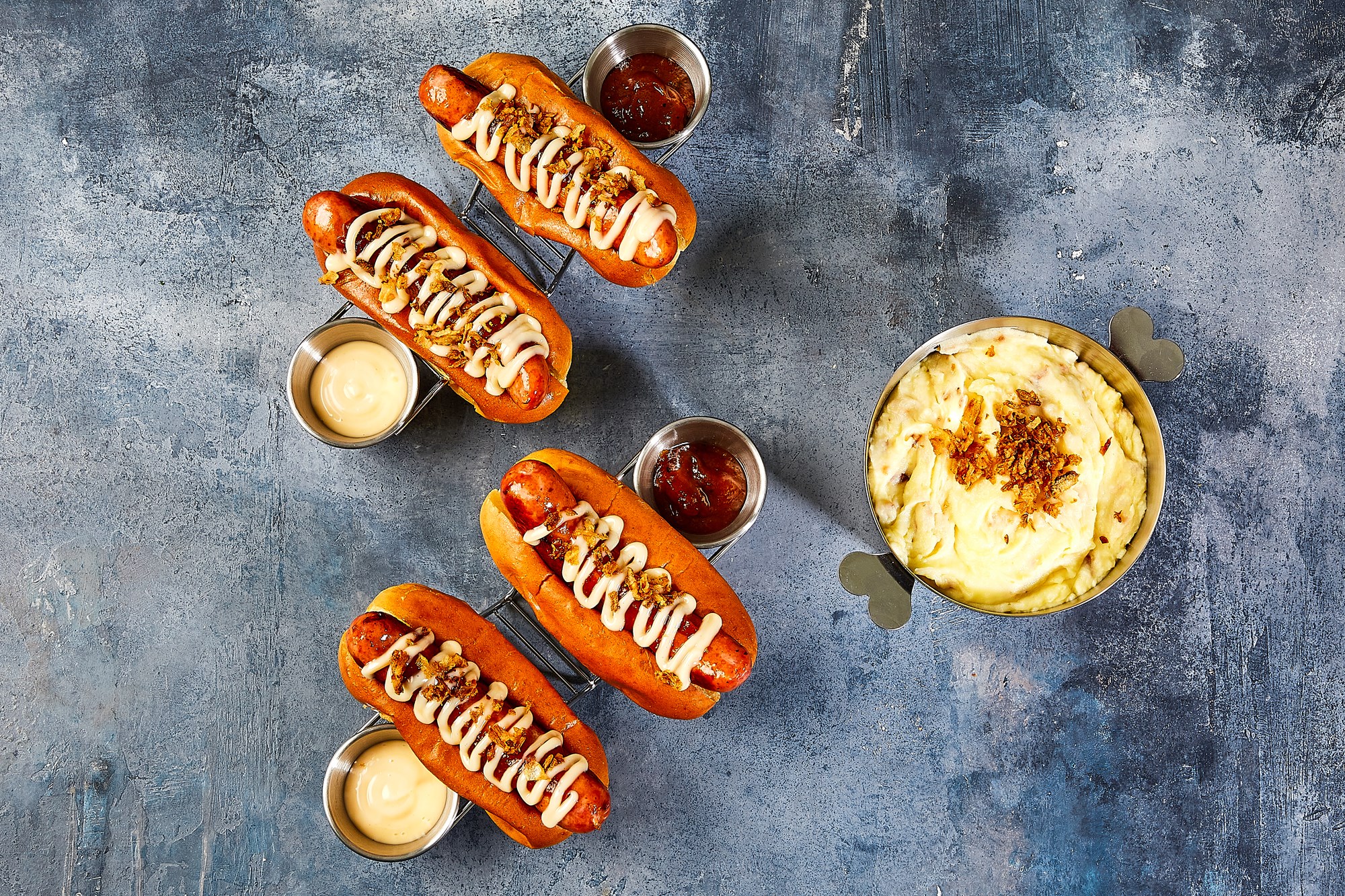 Hotdogs med baconfrankfurter, kartoffelmos & ristede løg