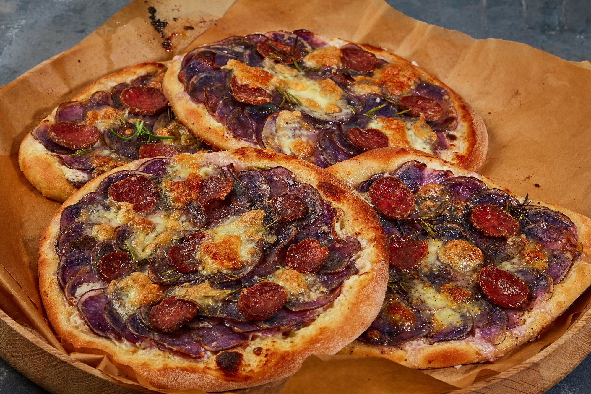 "Pizza bianco" med blå kartofler og salame cacciatore bagt med creme fraiche, rosmarin, citron & parmesan