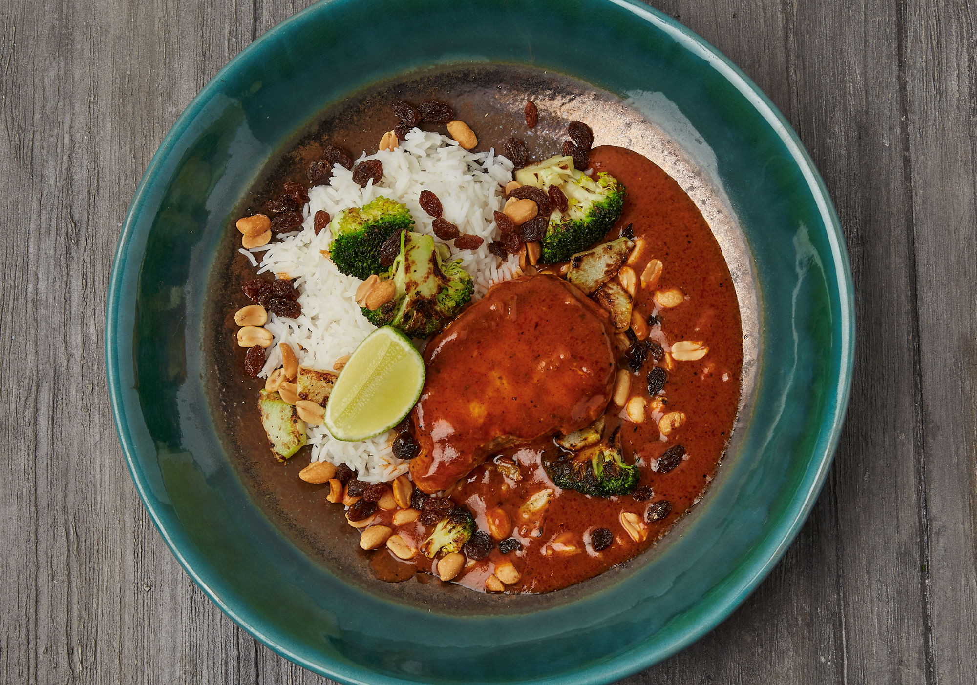 "Koteletter i fad" med mild indisk rød karry sovs, broccoli, peanuts, rosiner & ris